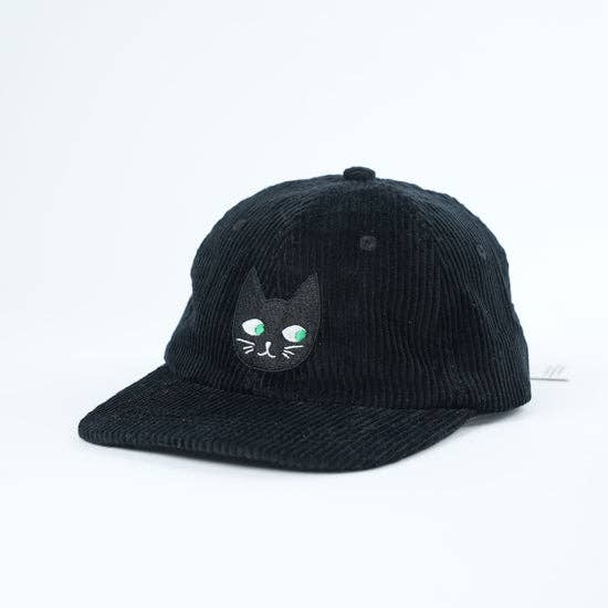 Black corduroy cap with a cat face design on a white background