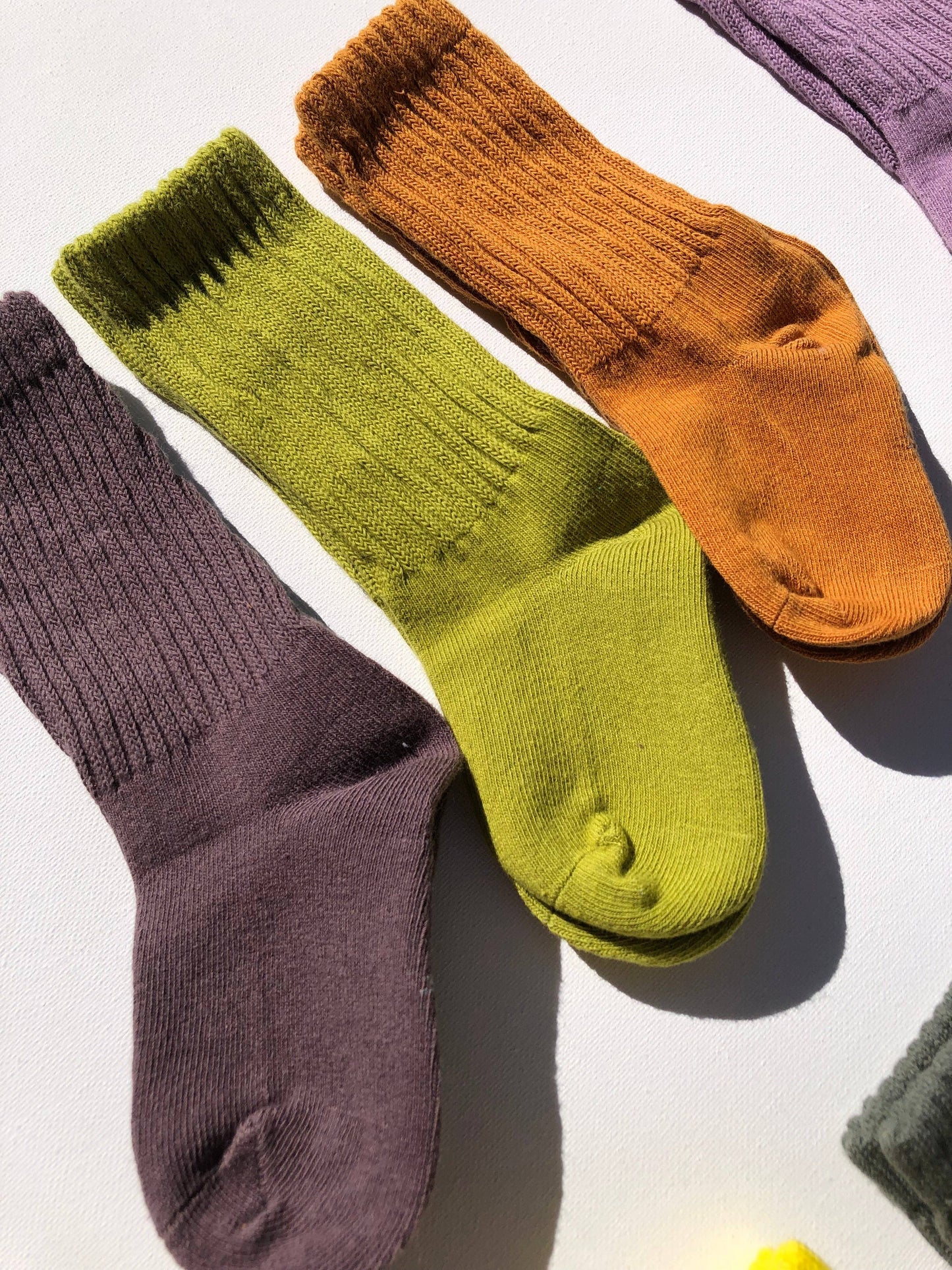 Colorful socks in green, orange, and purple on a light background