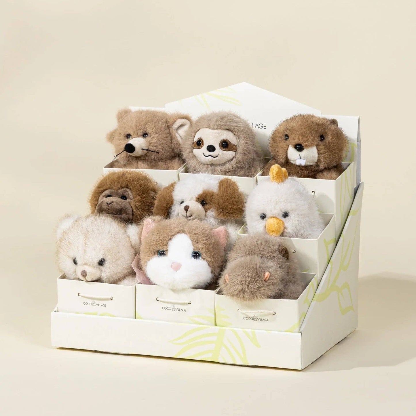 Set of small stuffed animals in a display box on a beige background