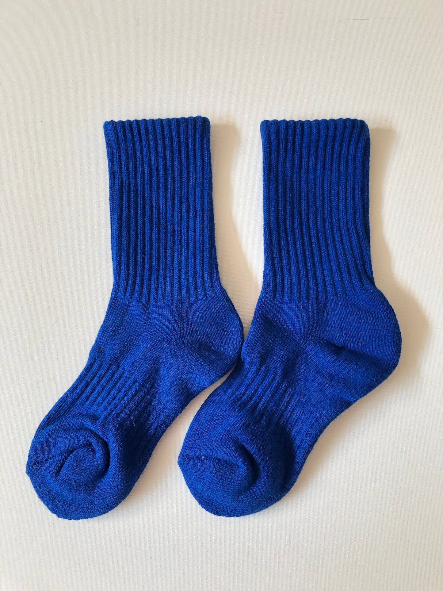 Pair of blue socks on a light beige background