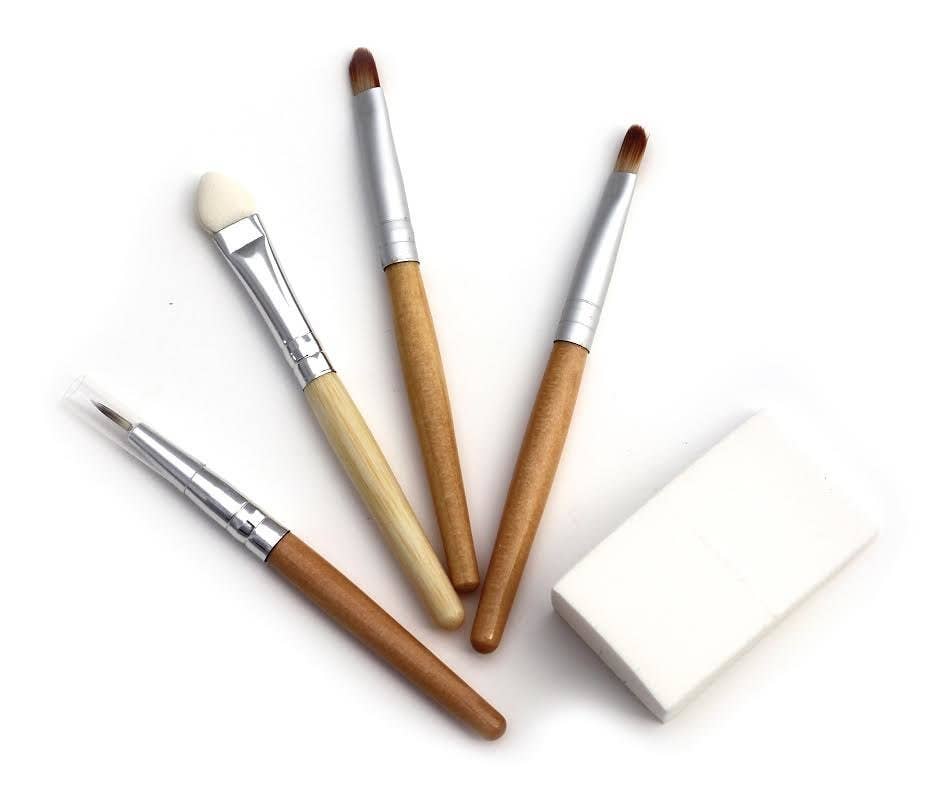 Set of makeup brushes with wooden handles on a white background