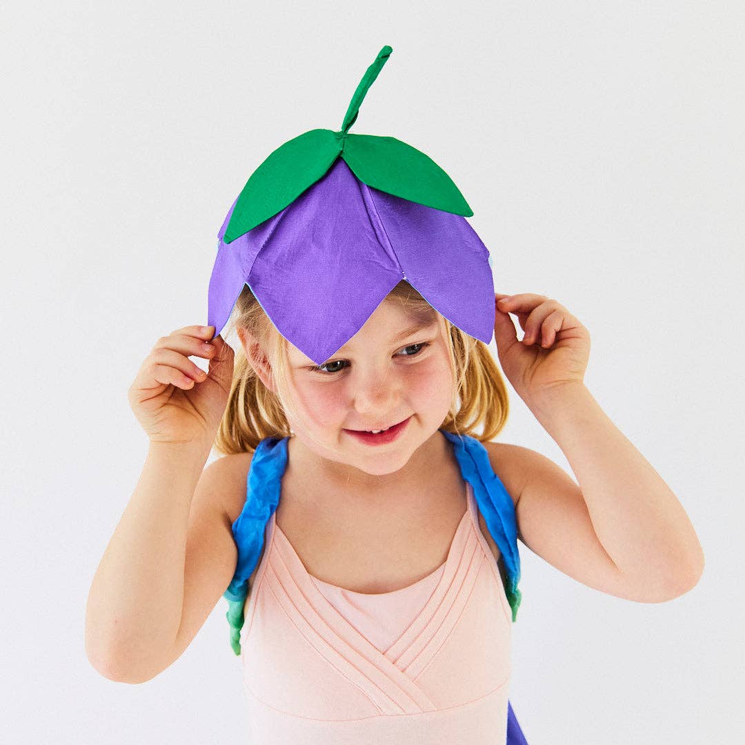 Child wearing a costume with a purple flower headpiece on a white background