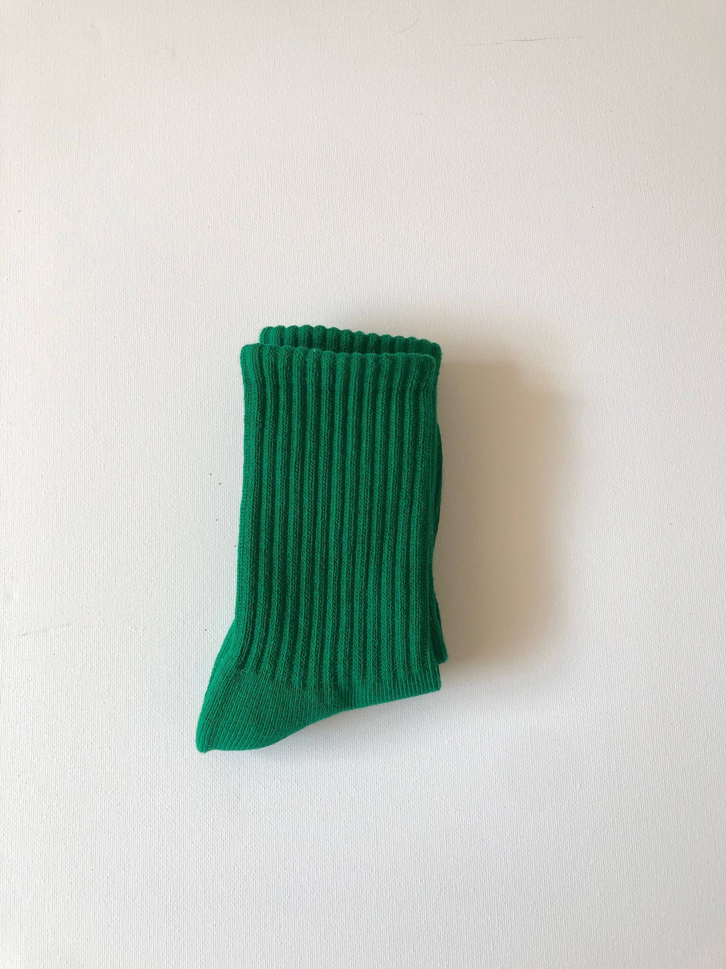Green ribbed sock on a white background