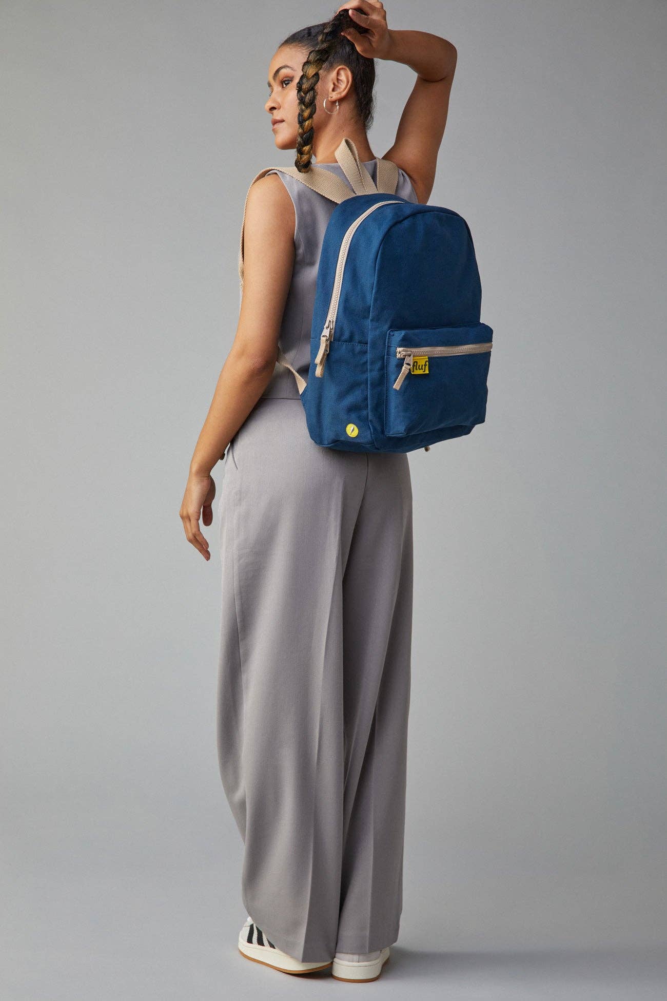 Person wearing a blue backpack on a gray background