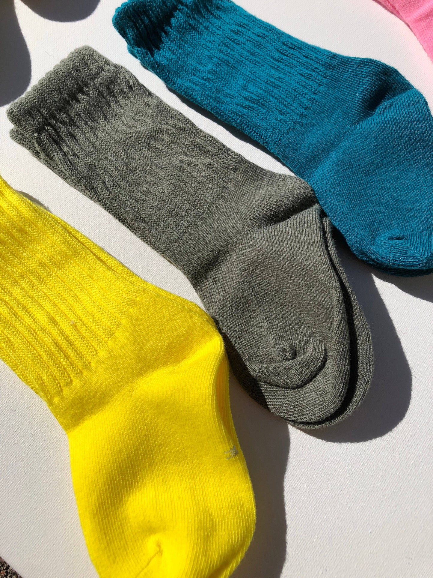 Three socks in yellow, gray, and blue on a light background