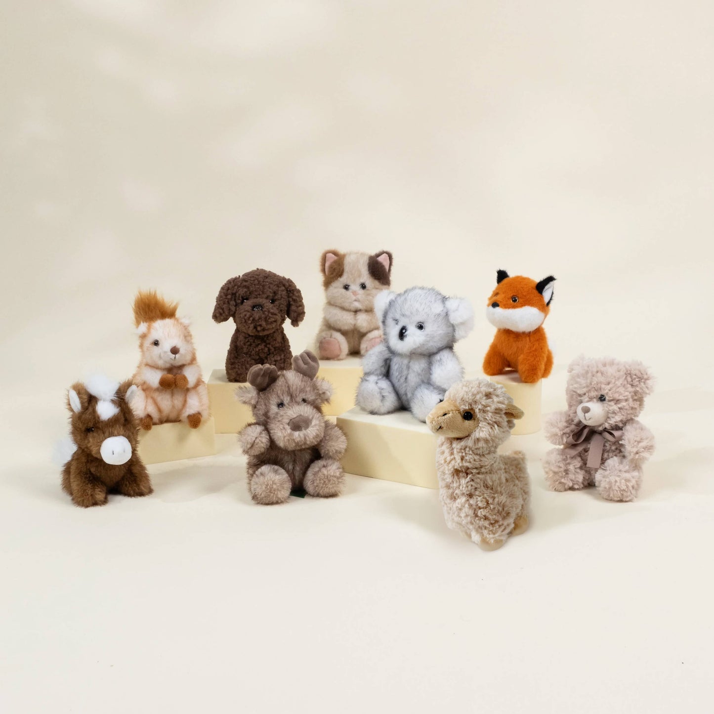 Collection of small stuffed animals on a beige background