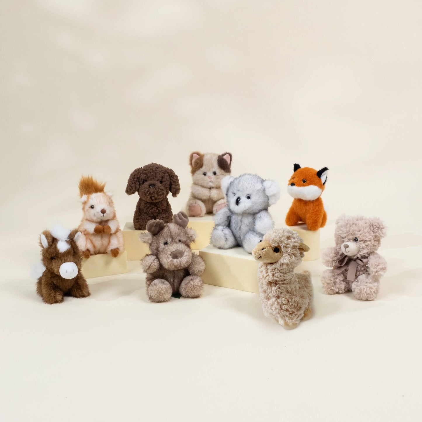 Collection of small stuffed animals on a beige background
