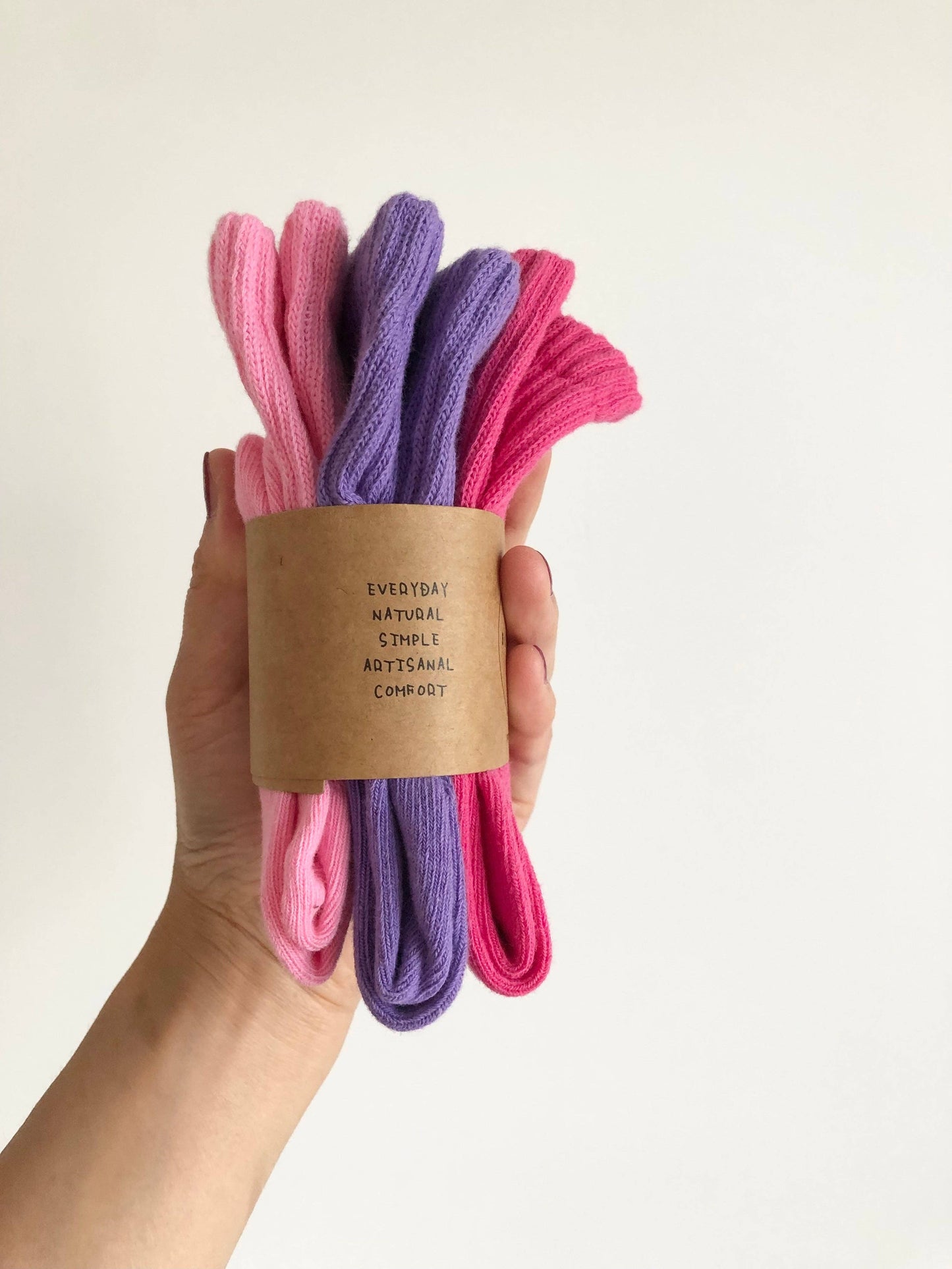 Hand holding a bundle of pink and purple socks