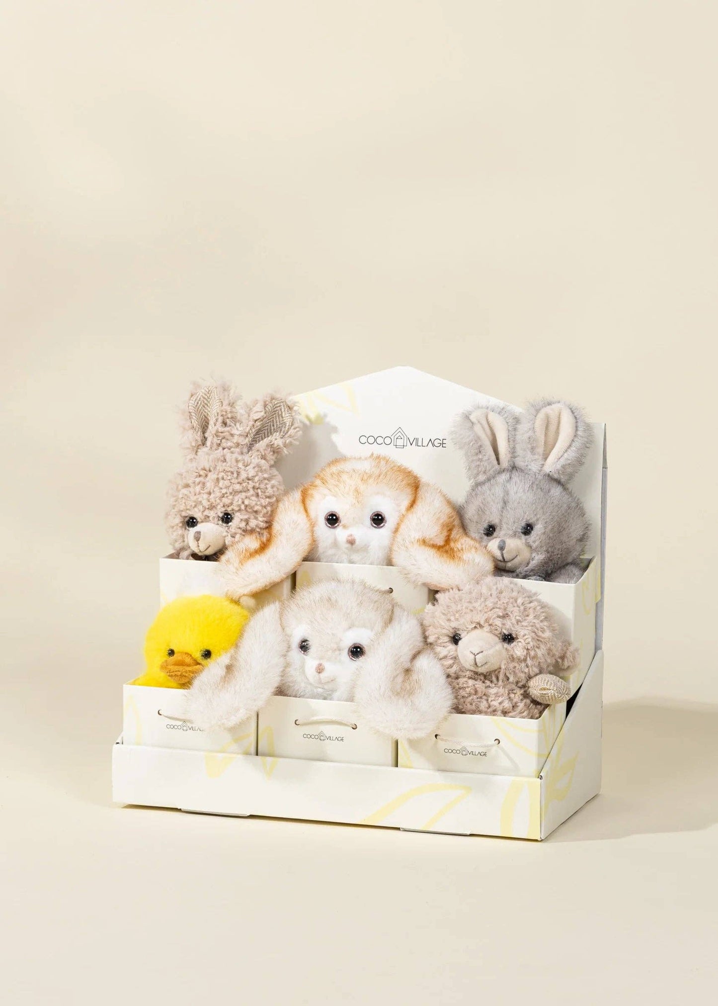 Set of small plush toys in a box on a beige background