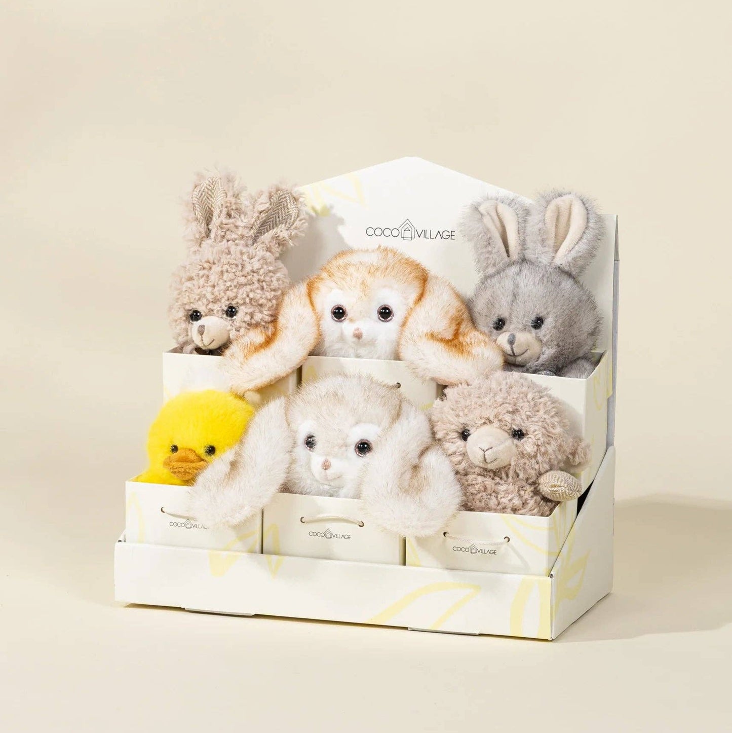 Set of small plush toys in a box on a beige background