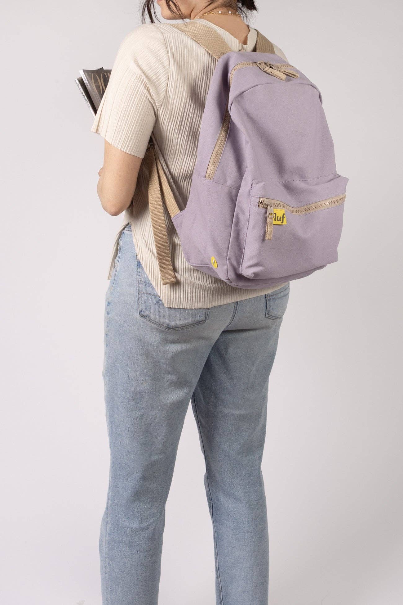 Person wearing a purple backpack on a plain background
