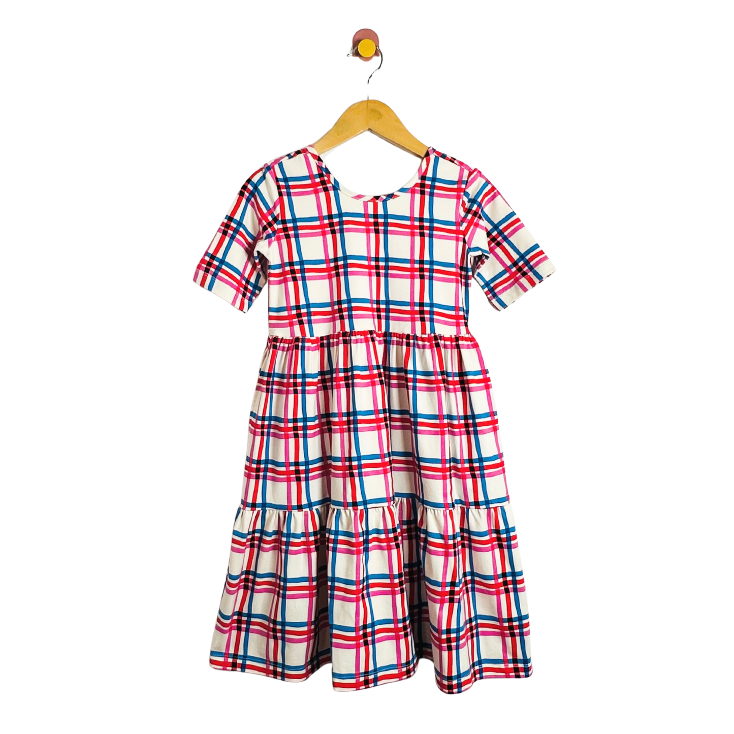 Plaid dress on a hanger against a white background