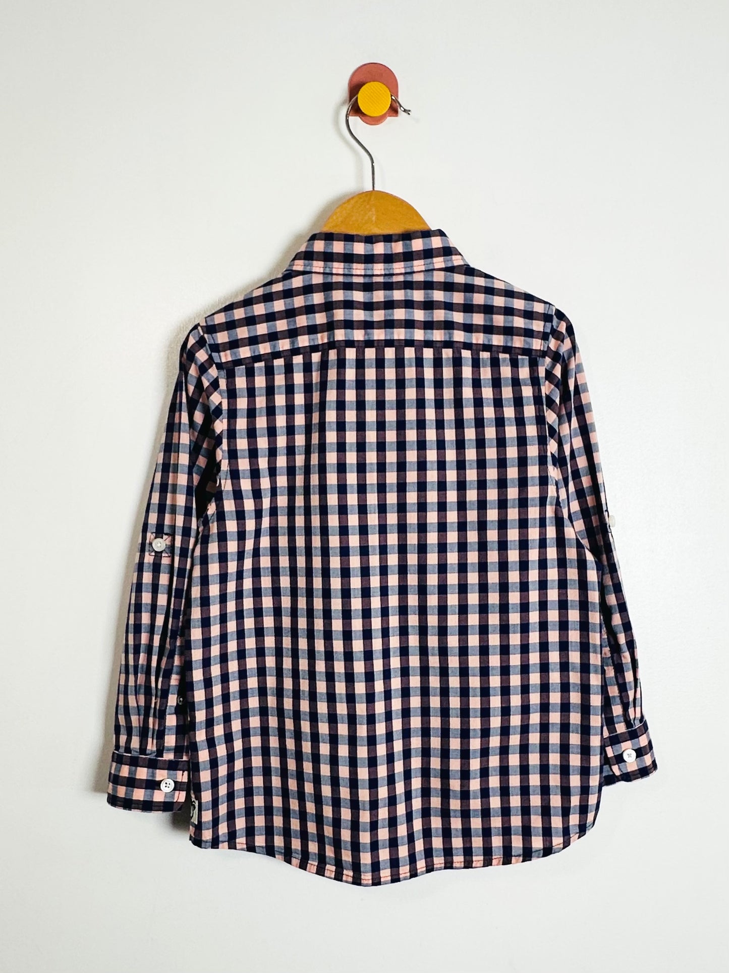 Checkered shirt on a hanger against a white background