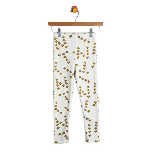 White pants with gold star pattern on a hanger against a white background