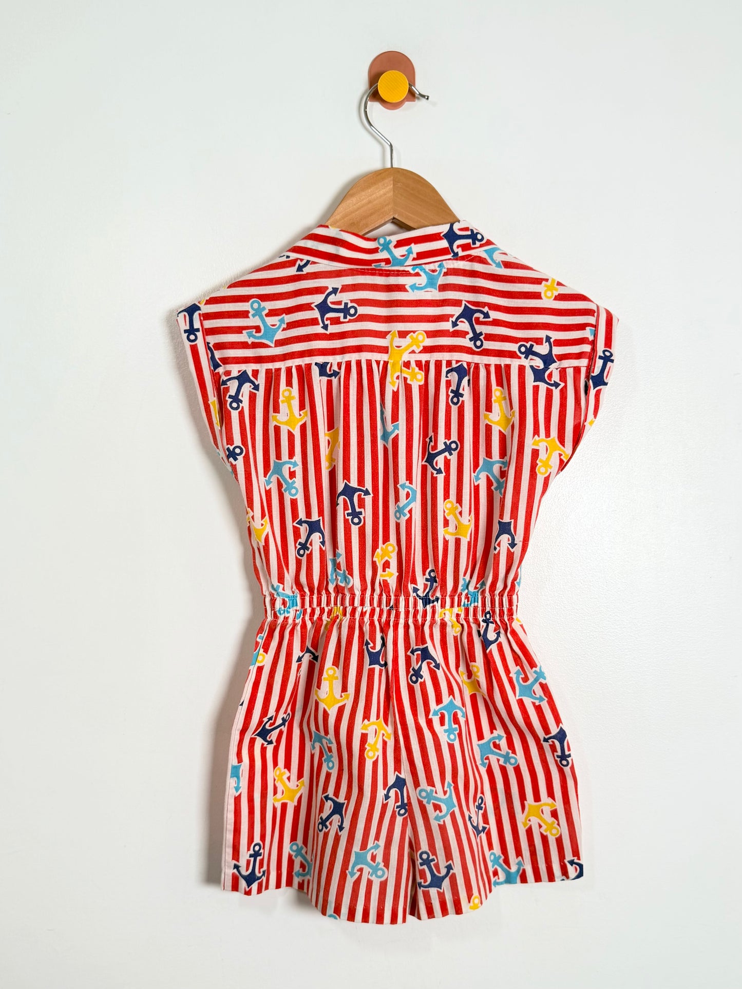 Red and white striped dress with animal print on a hanger against a white background