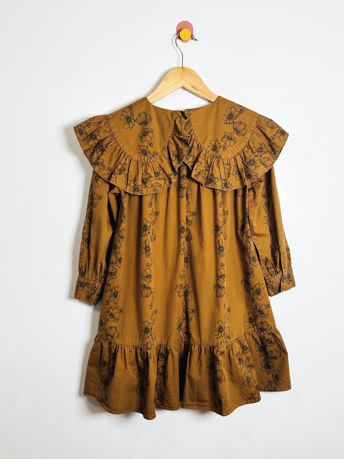 Brown floral dress with ruffled collar on a white background