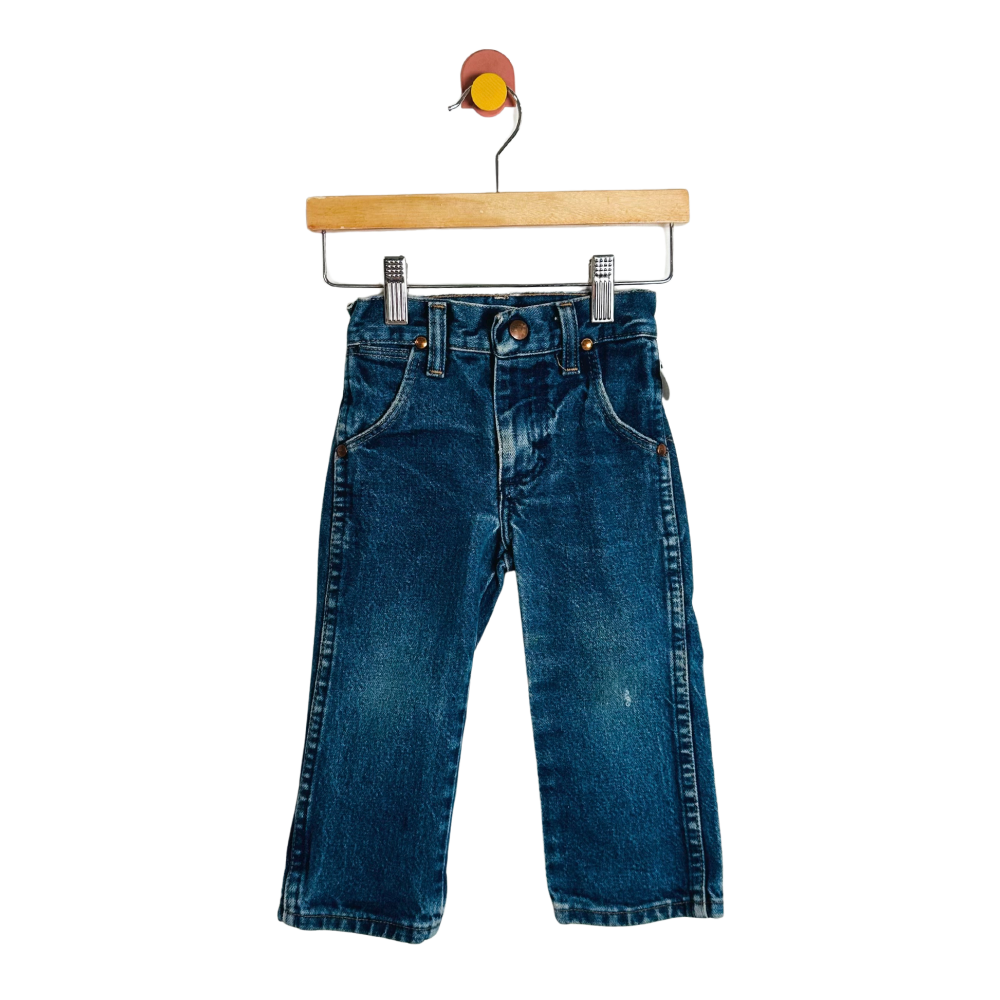 Blue jeans on a wooden hanger against a white background