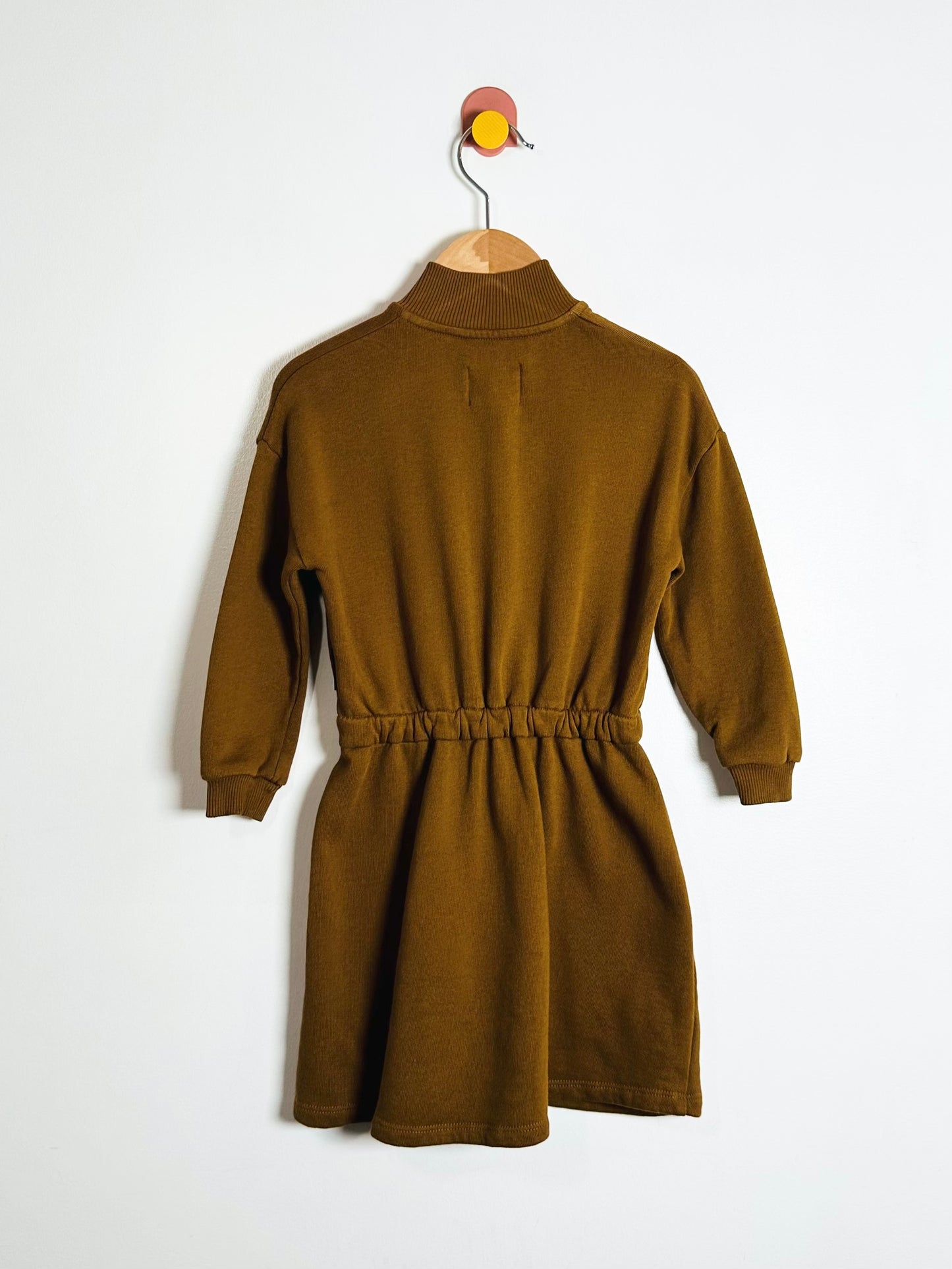 Brown dress on a hanger against a white background