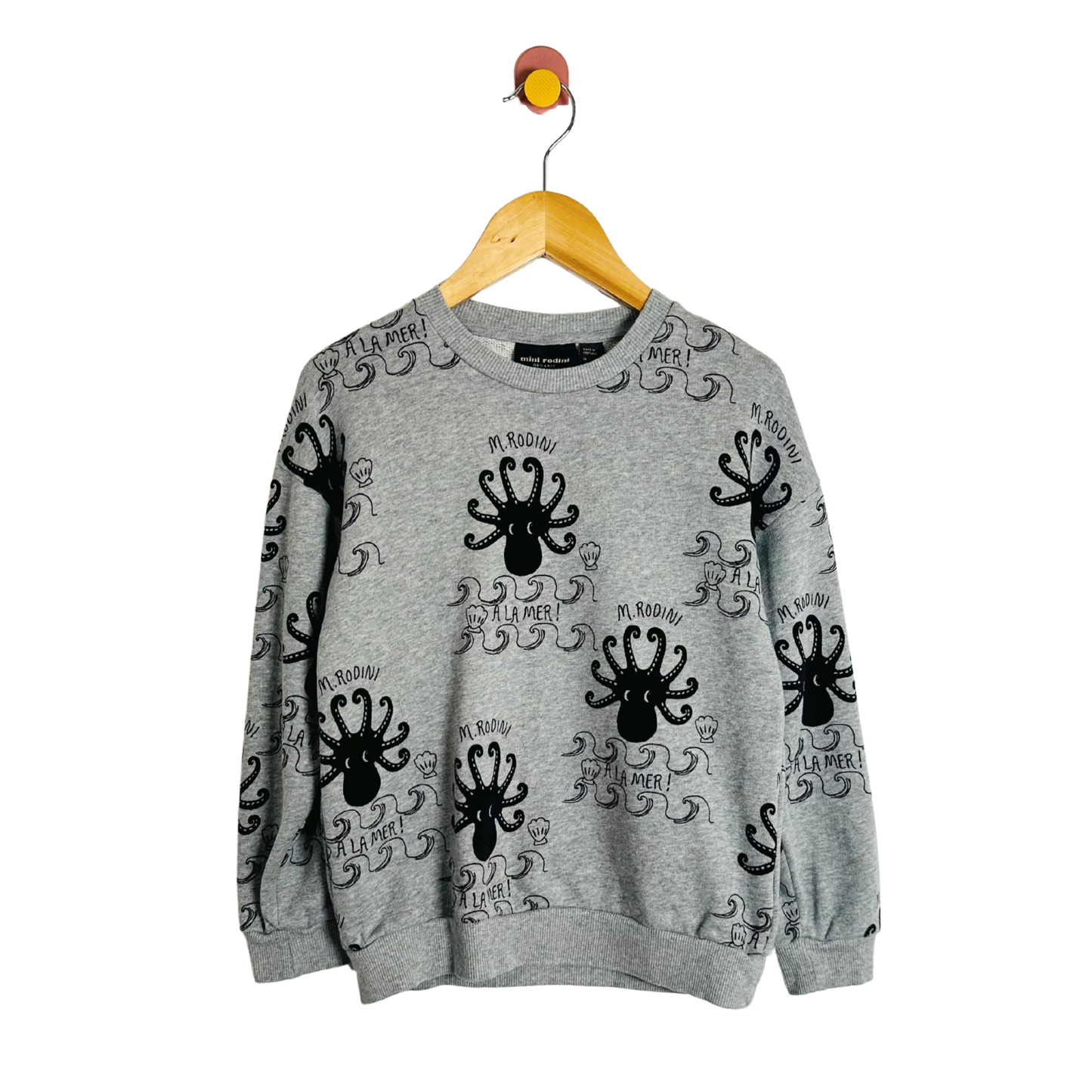Gray sweatshirt with black octopus designs on a hanger against a white background