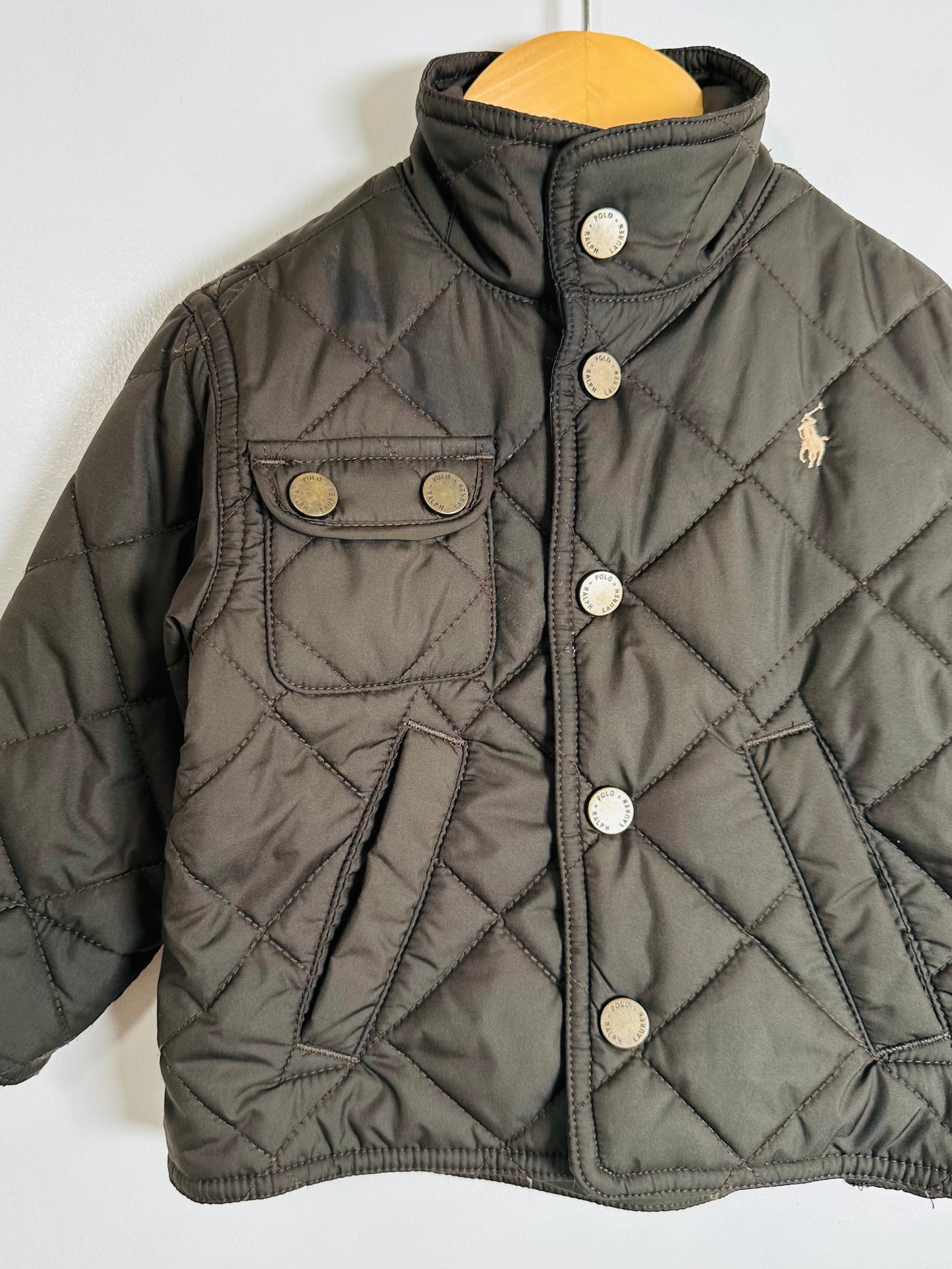 Quilted jacket with button details on a mannequin against a white background