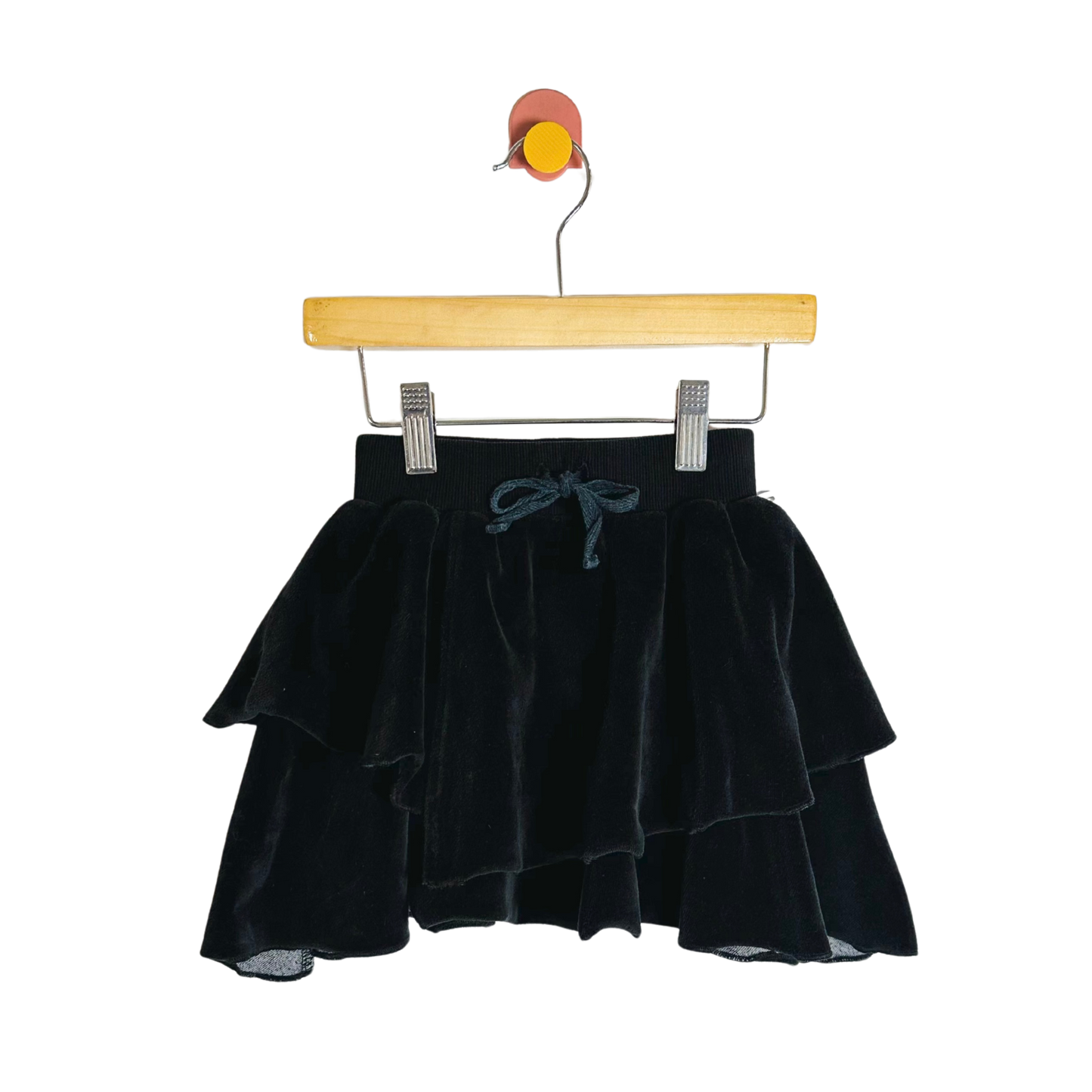 Black velvet skirt on a wooden hanger against a white background