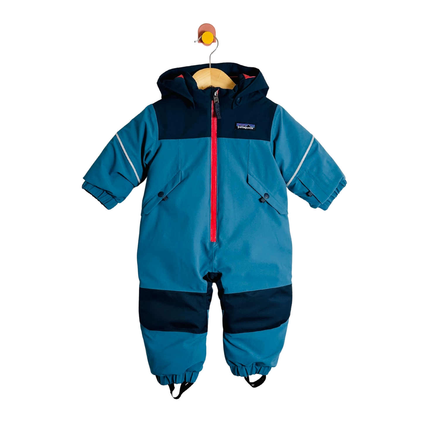 Blue children's snowsuit with red zipper on a white background