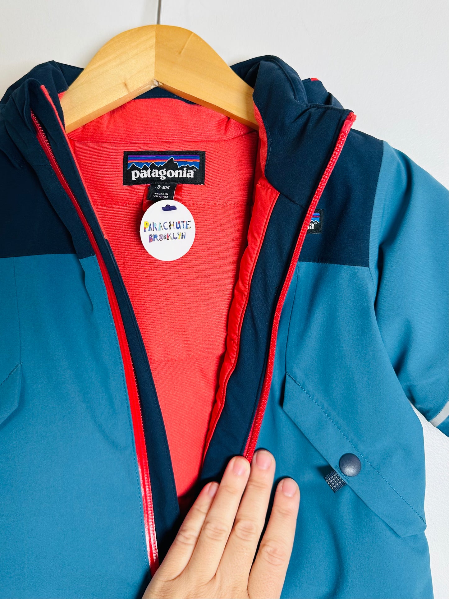 Blue and red snowsuit with Patagonia logo on a hanger