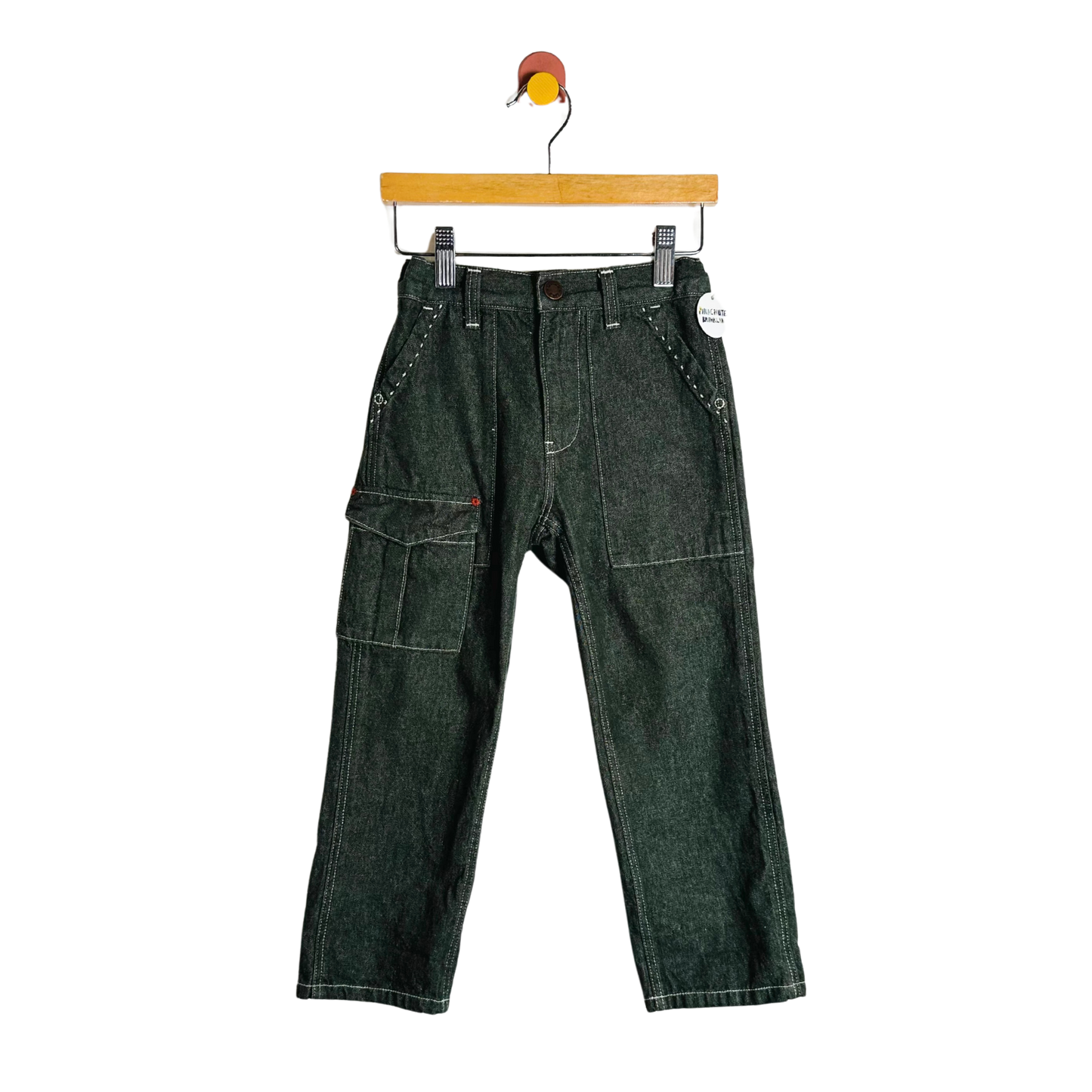 Green denim pants on a hanger against a white background
