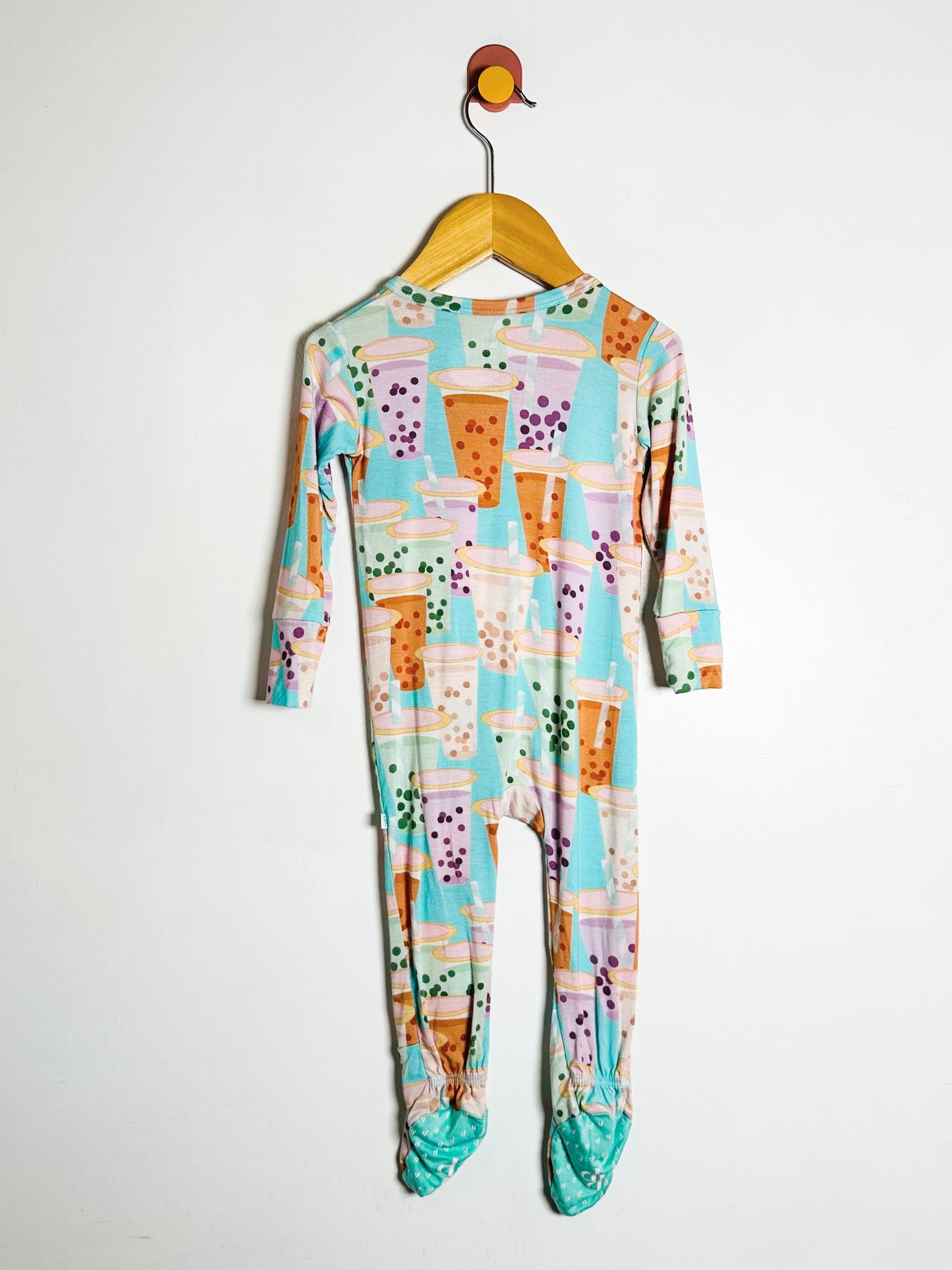 Colorful baby onesie with a pattern on a hanger against a white background