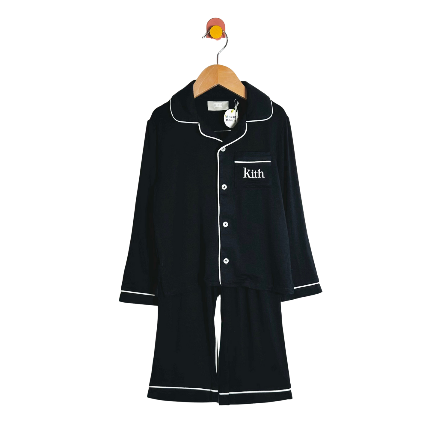 Black pajama set with white piping on a hanger against a white background