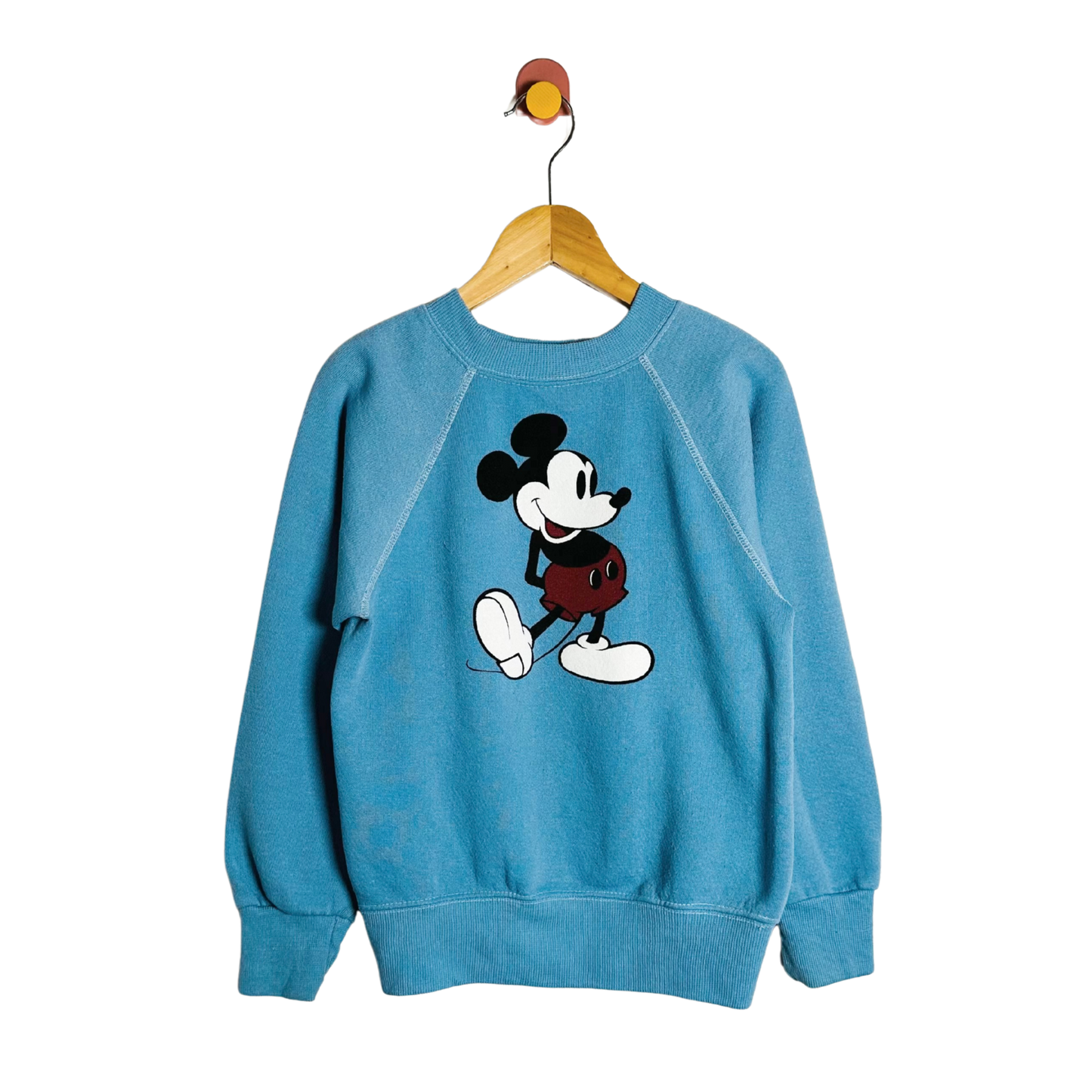 Blue sweatshirt with a cartoon character on a hanger against a white background