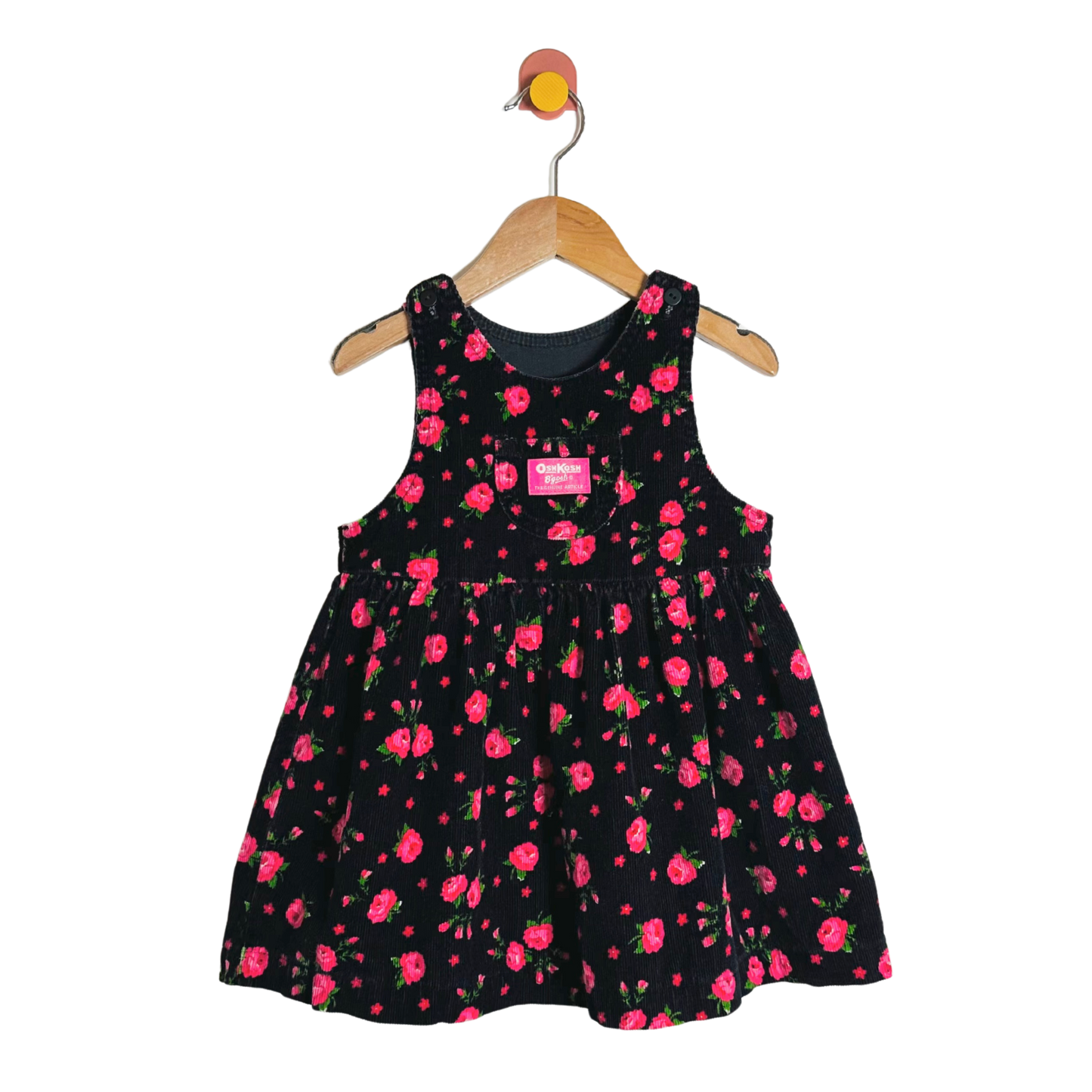 Black dress with pink floral pattern on a hanger against a white background