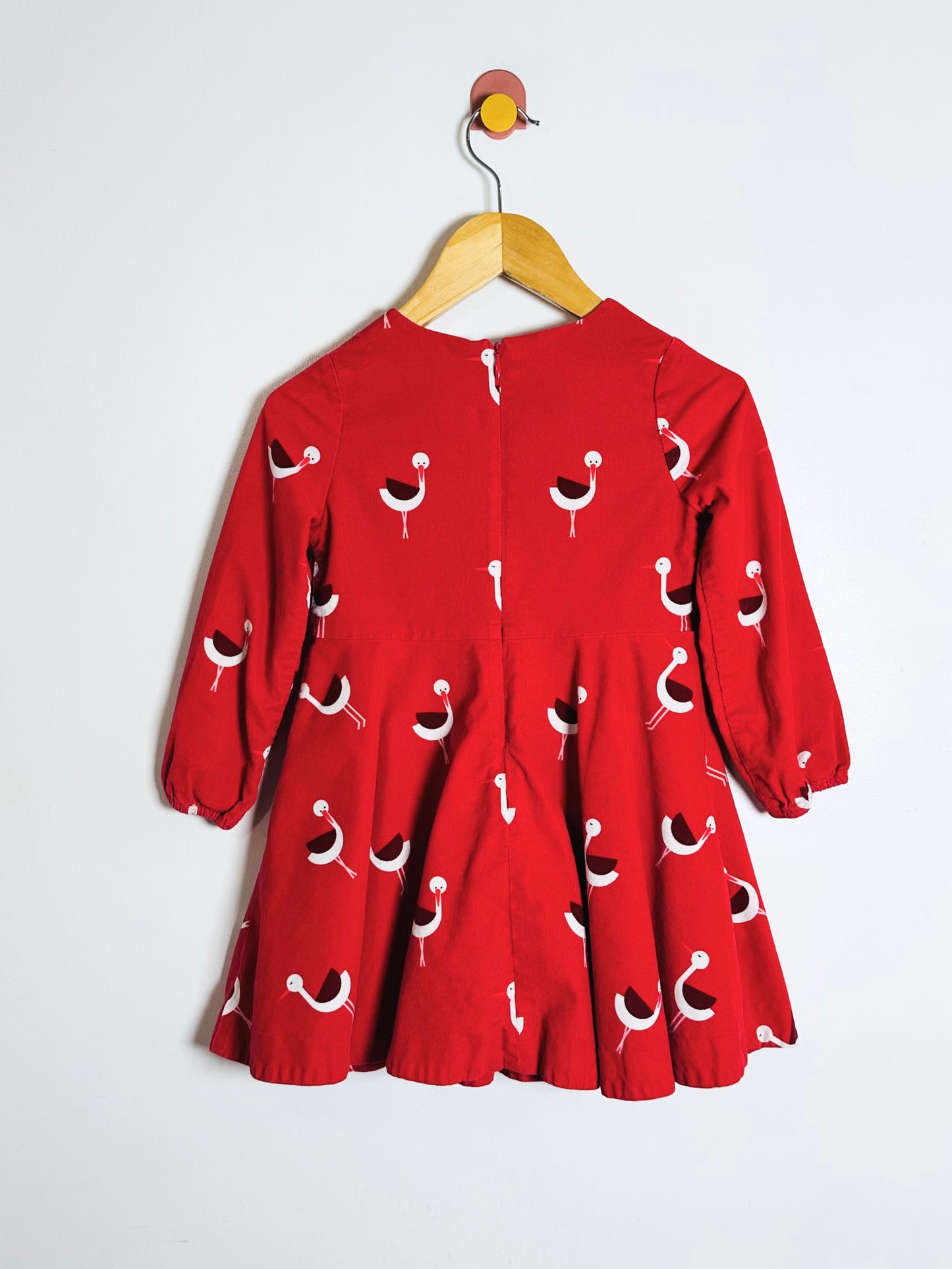 Red dress with a pattern on a hanger against a white background