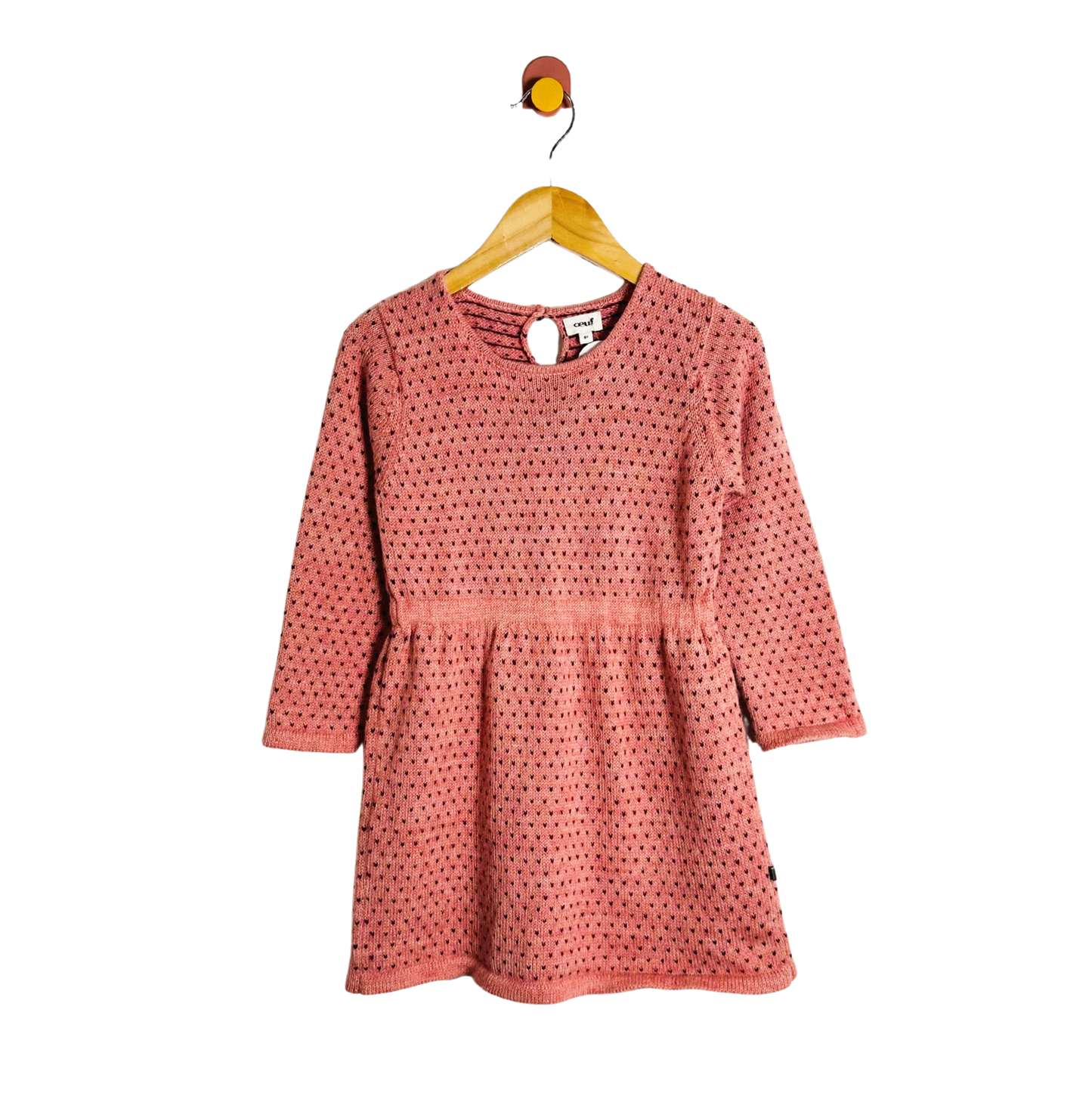 Pink polka dot dress on a hanger against a white background