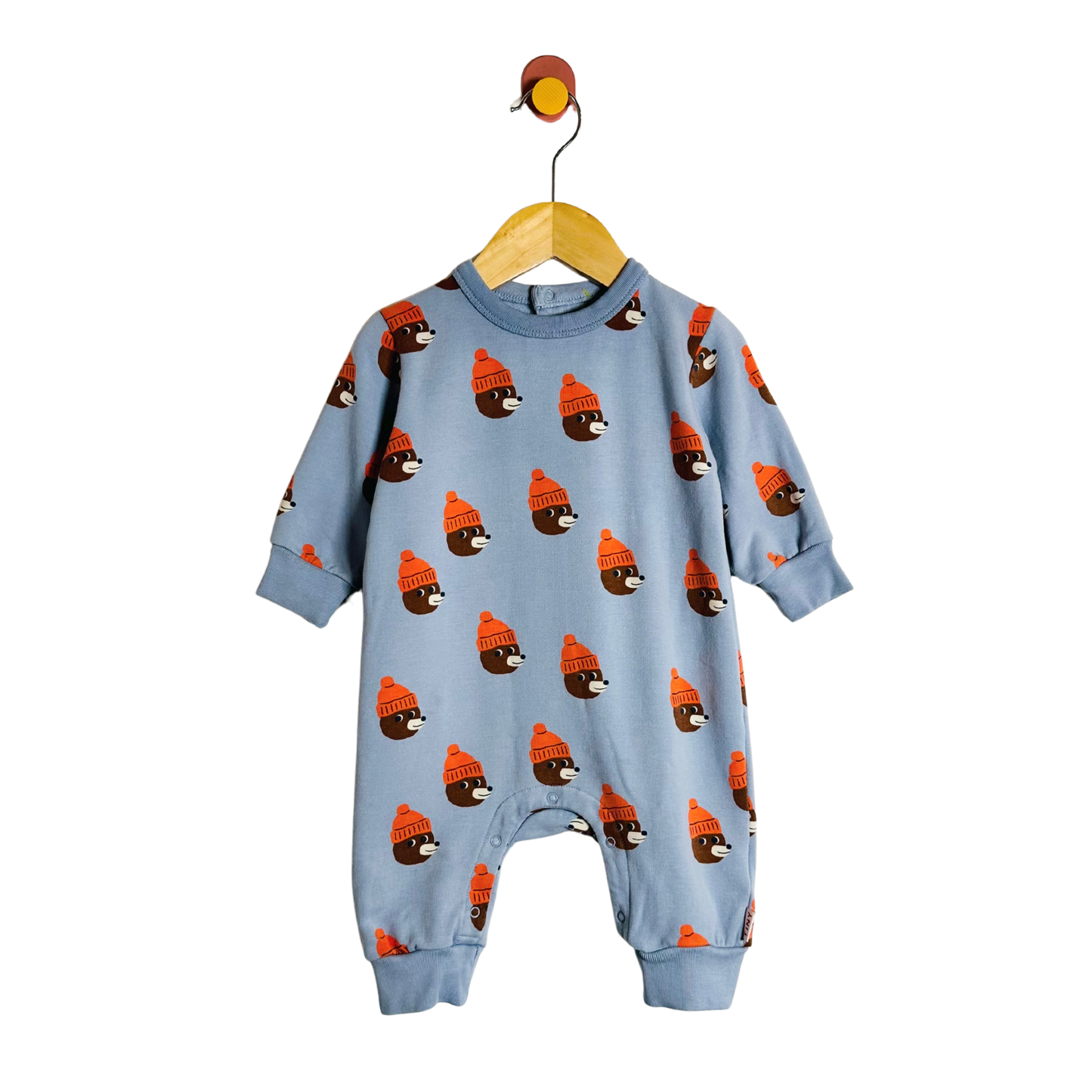 Blue baby onesie with bear pattern on a hanger against a white background