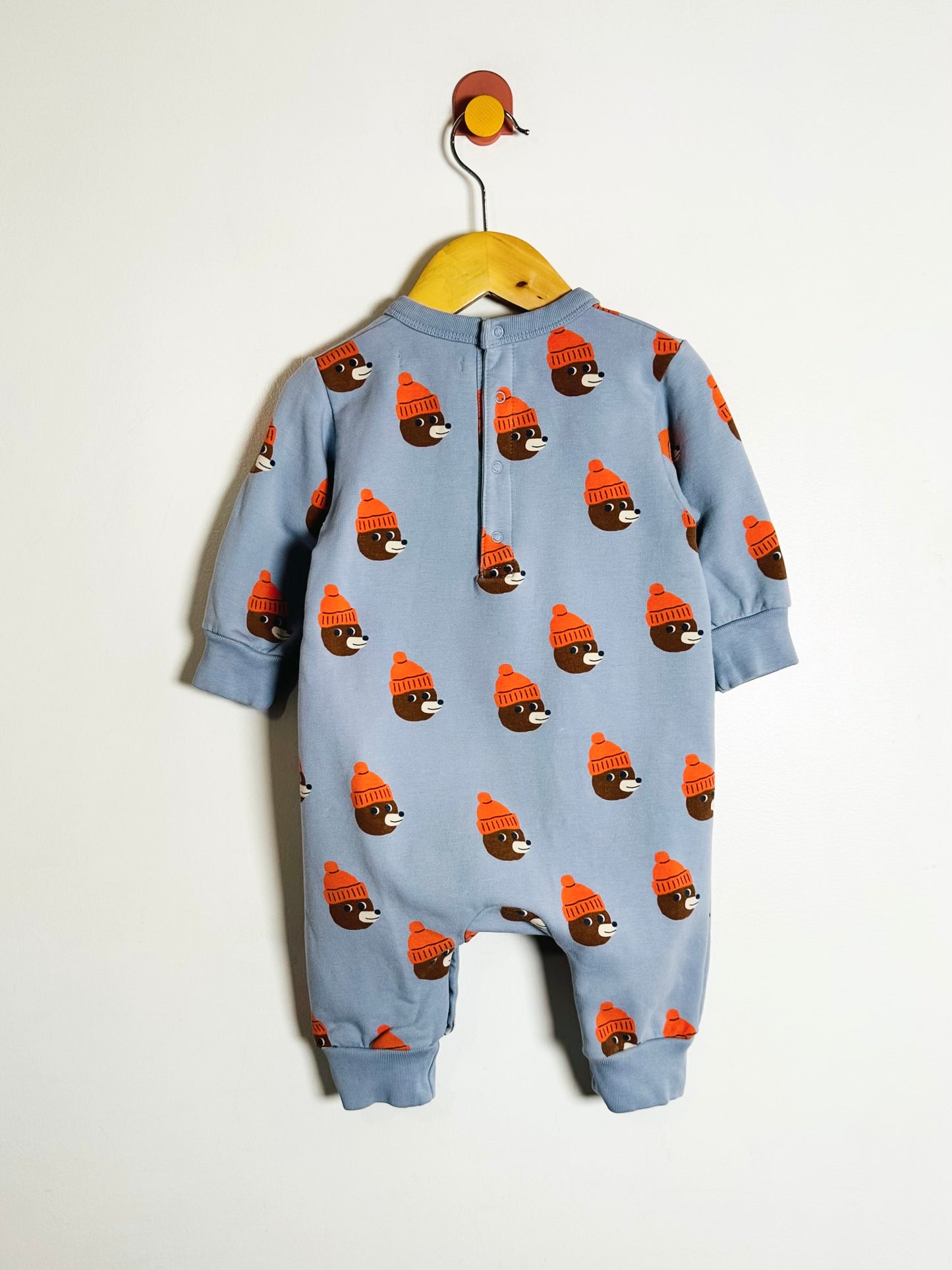 Blue baby onesie with bear pattern on a white background
