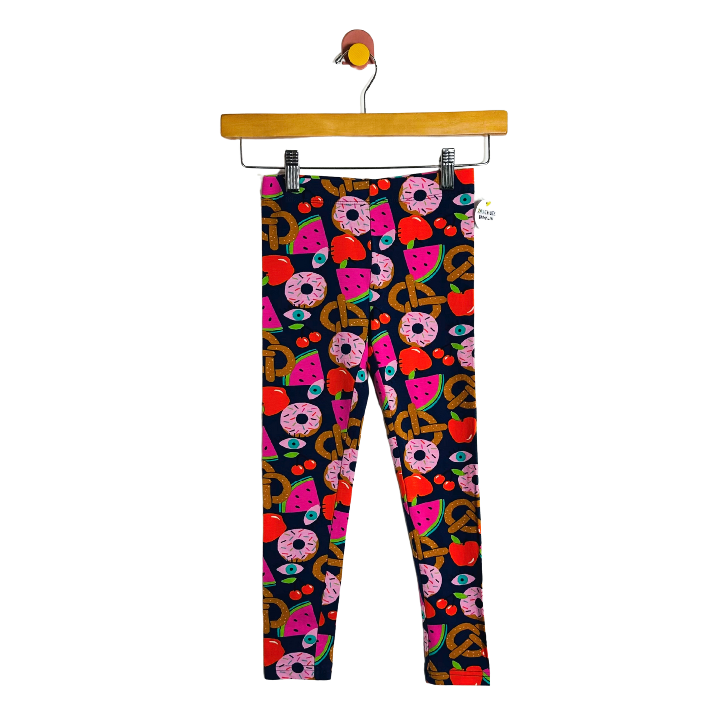Colorful patterned leggings on a hanger against a white background