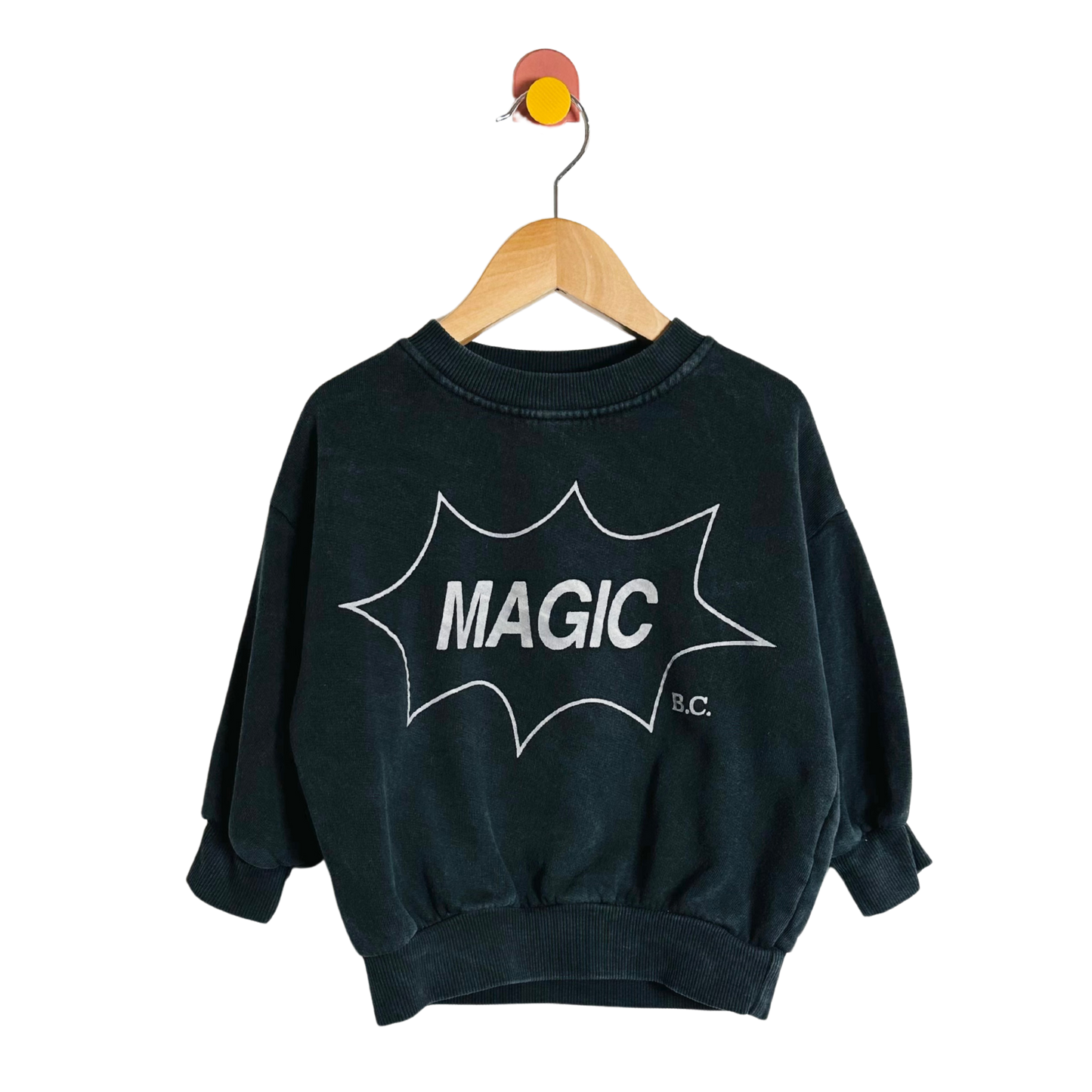 Black sweatshirt with 'MAGIC B.C.' print on a hanger against a white background