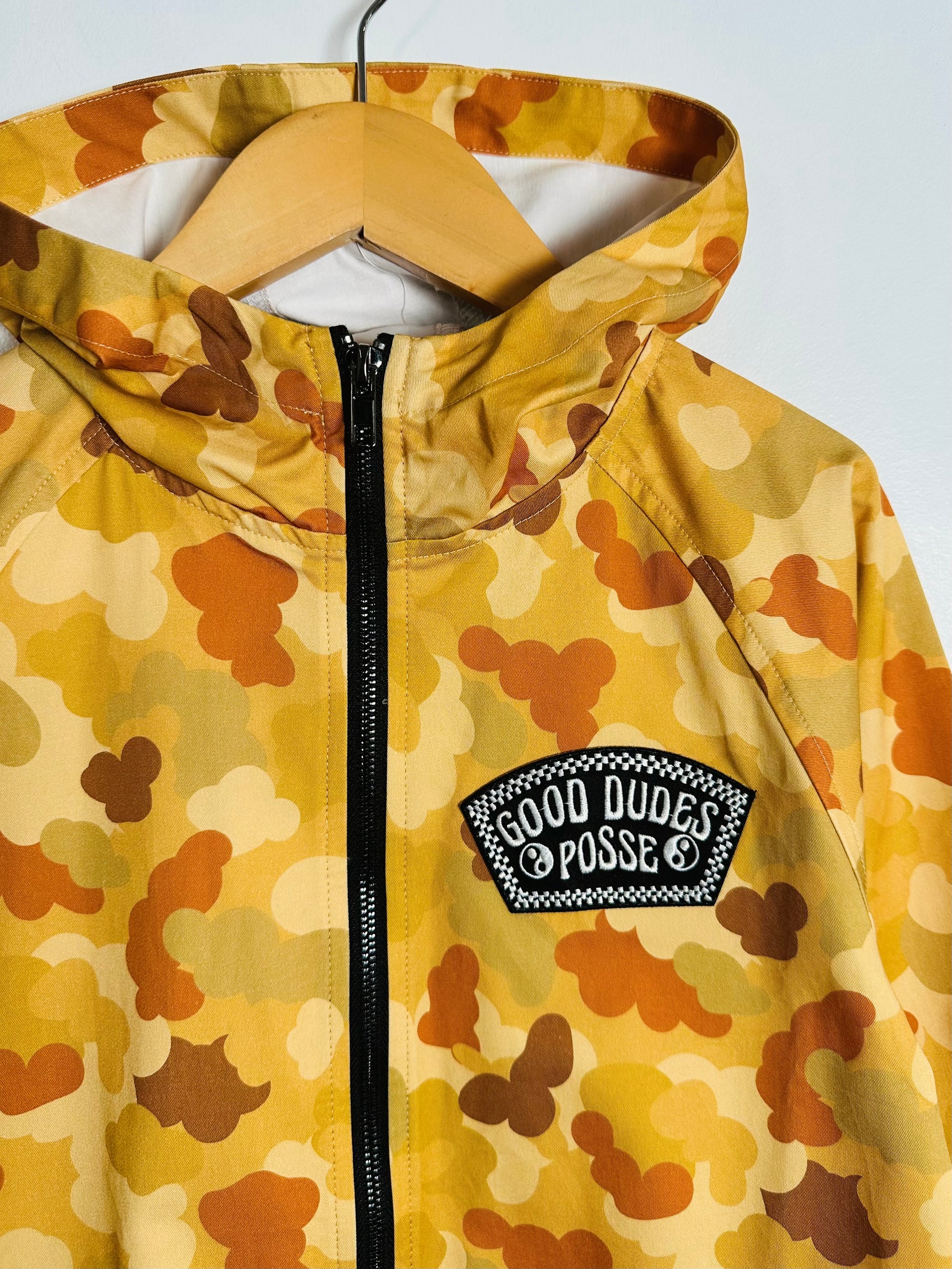 Camouflage-patterned jacket with a visible brand logo on a white background