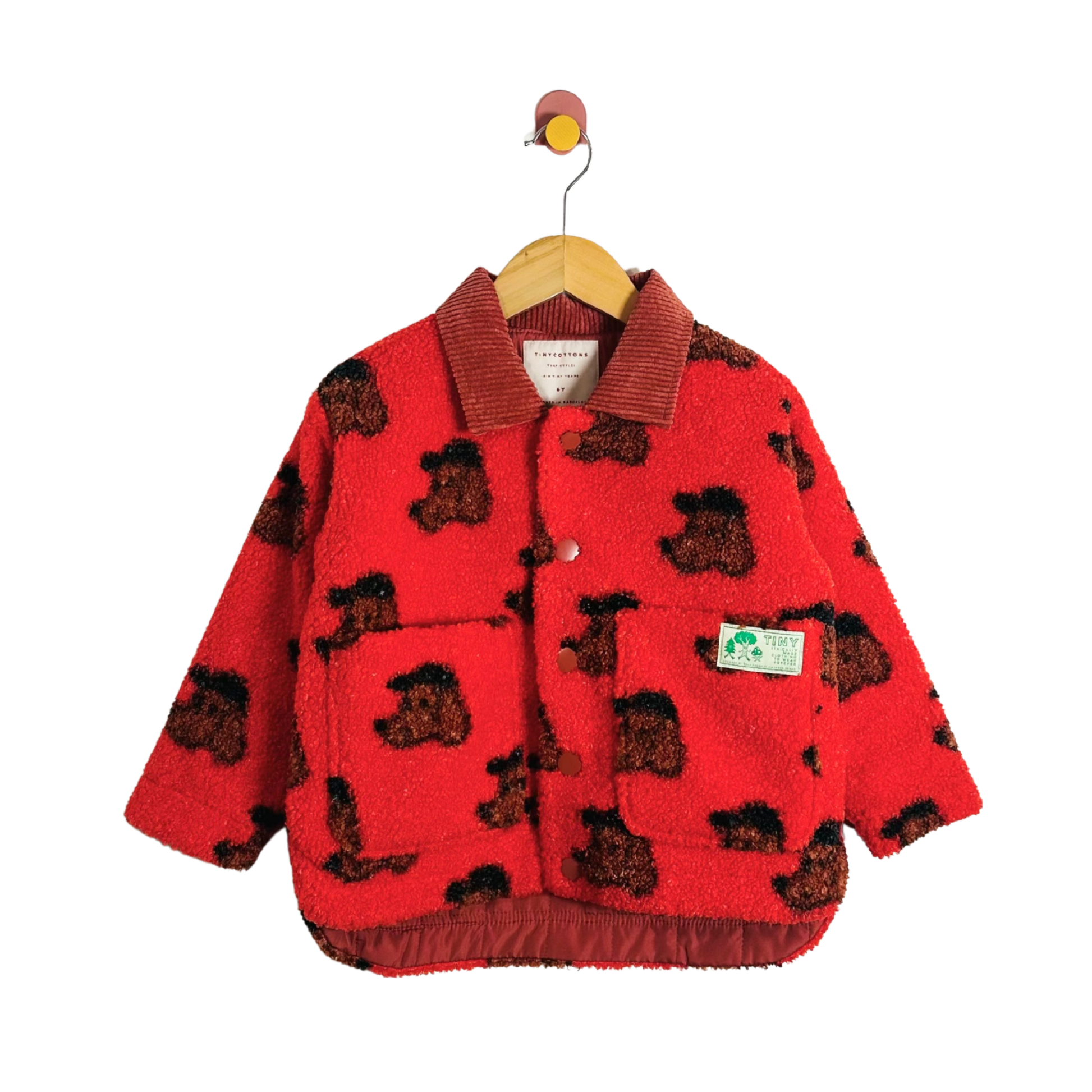 Red children's jacket with dog pattern on a hanger against a white background