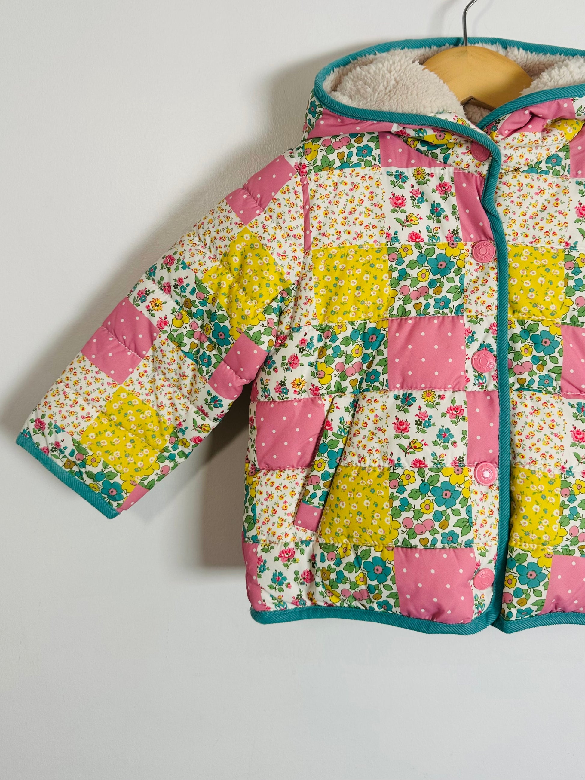 Children's quilted jacket with floral patchwork design on a white background