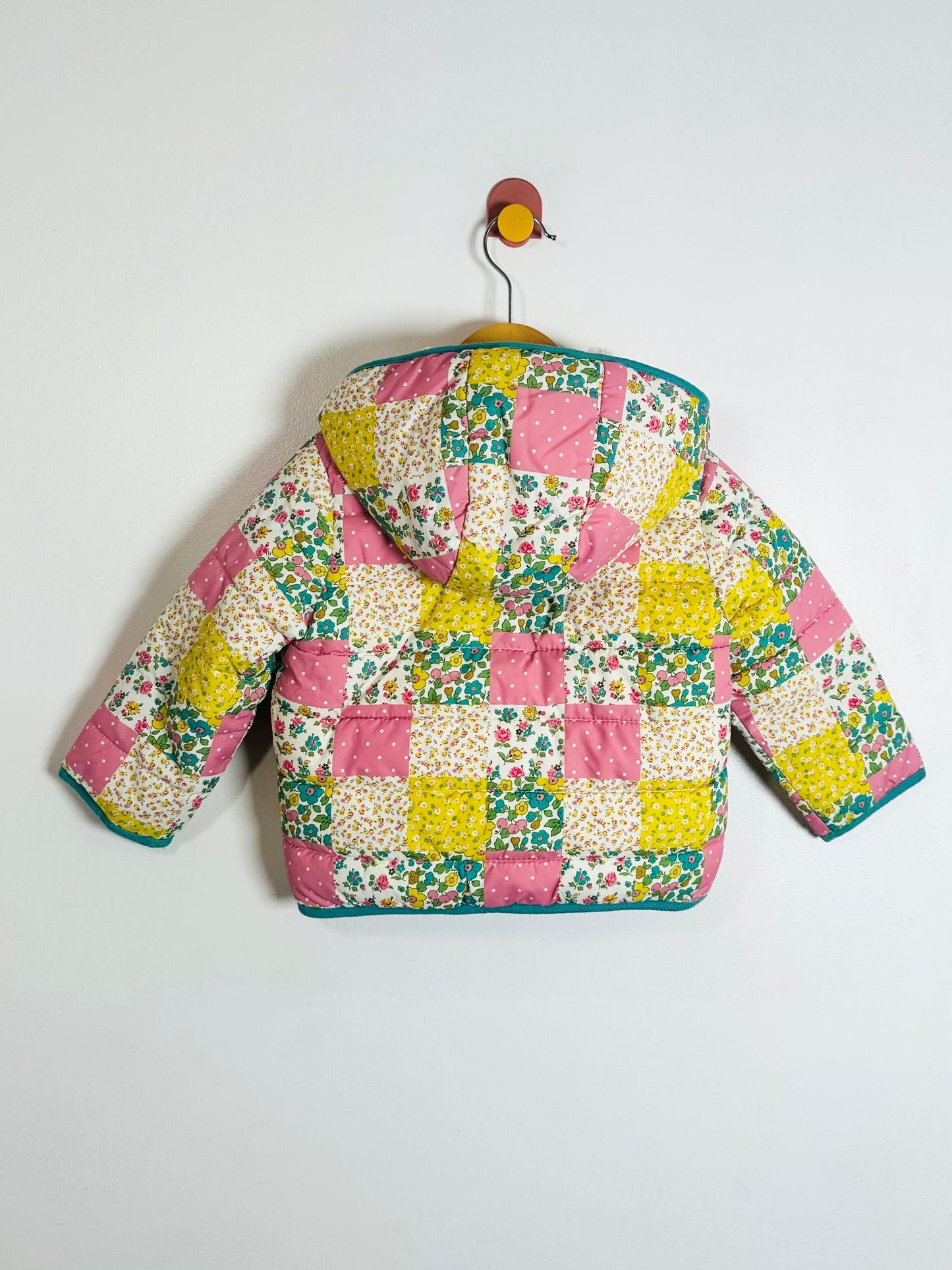 Colorful patchwork quilted jacket on a white background
