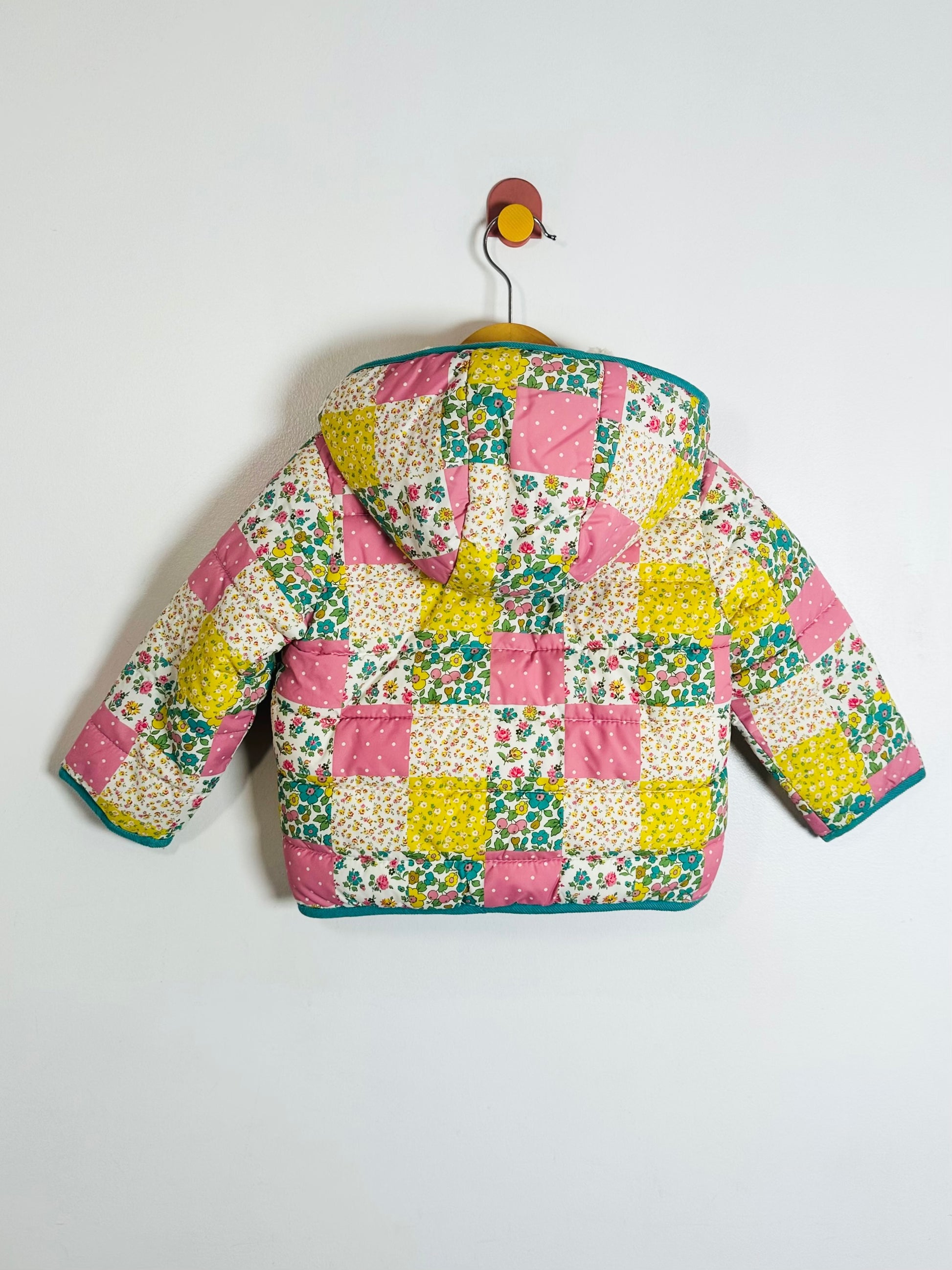 Colorful patchwork quilted jacket on a white background
