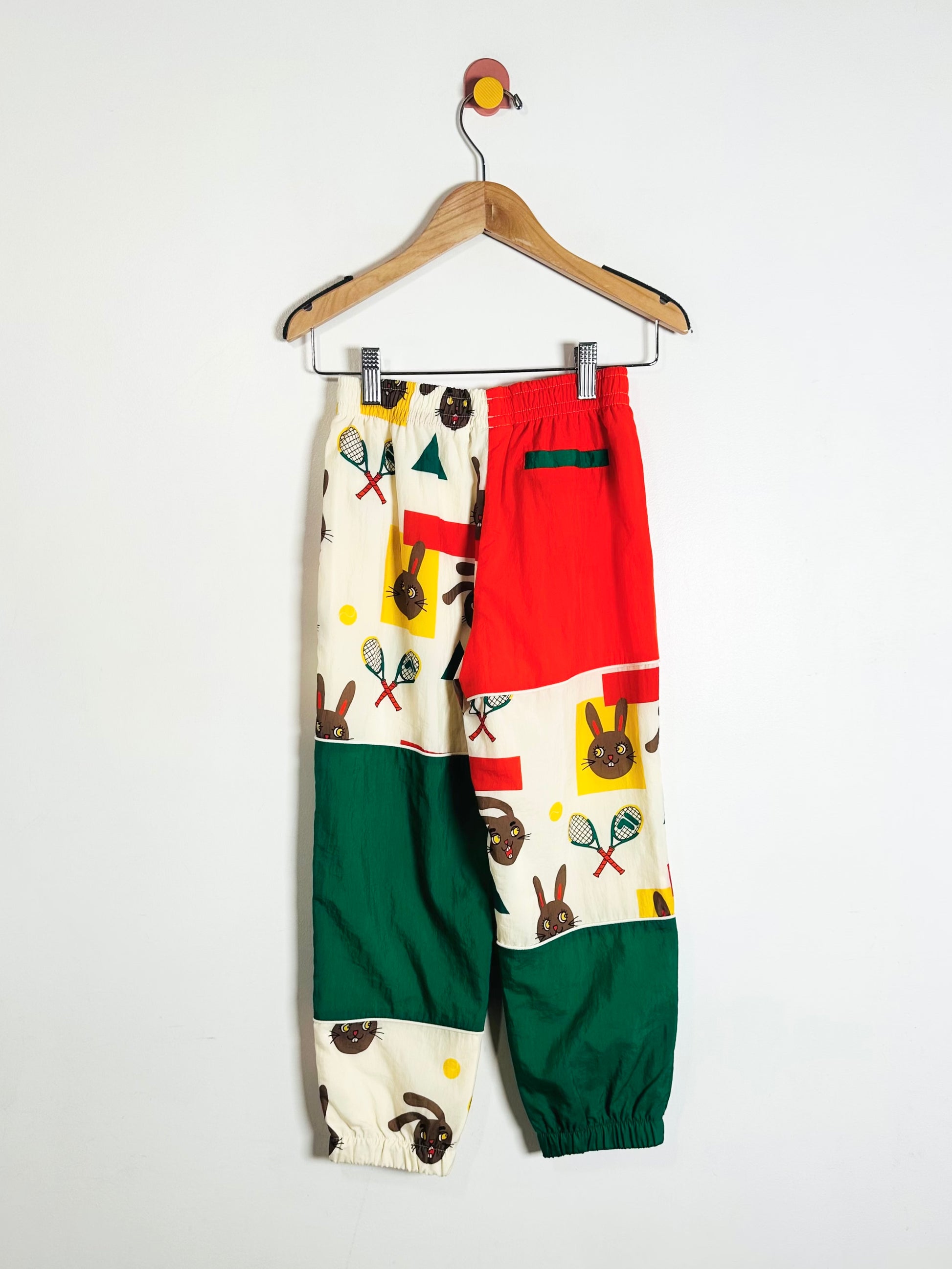 Colorful children's pants with pattern on a hanger against a white background