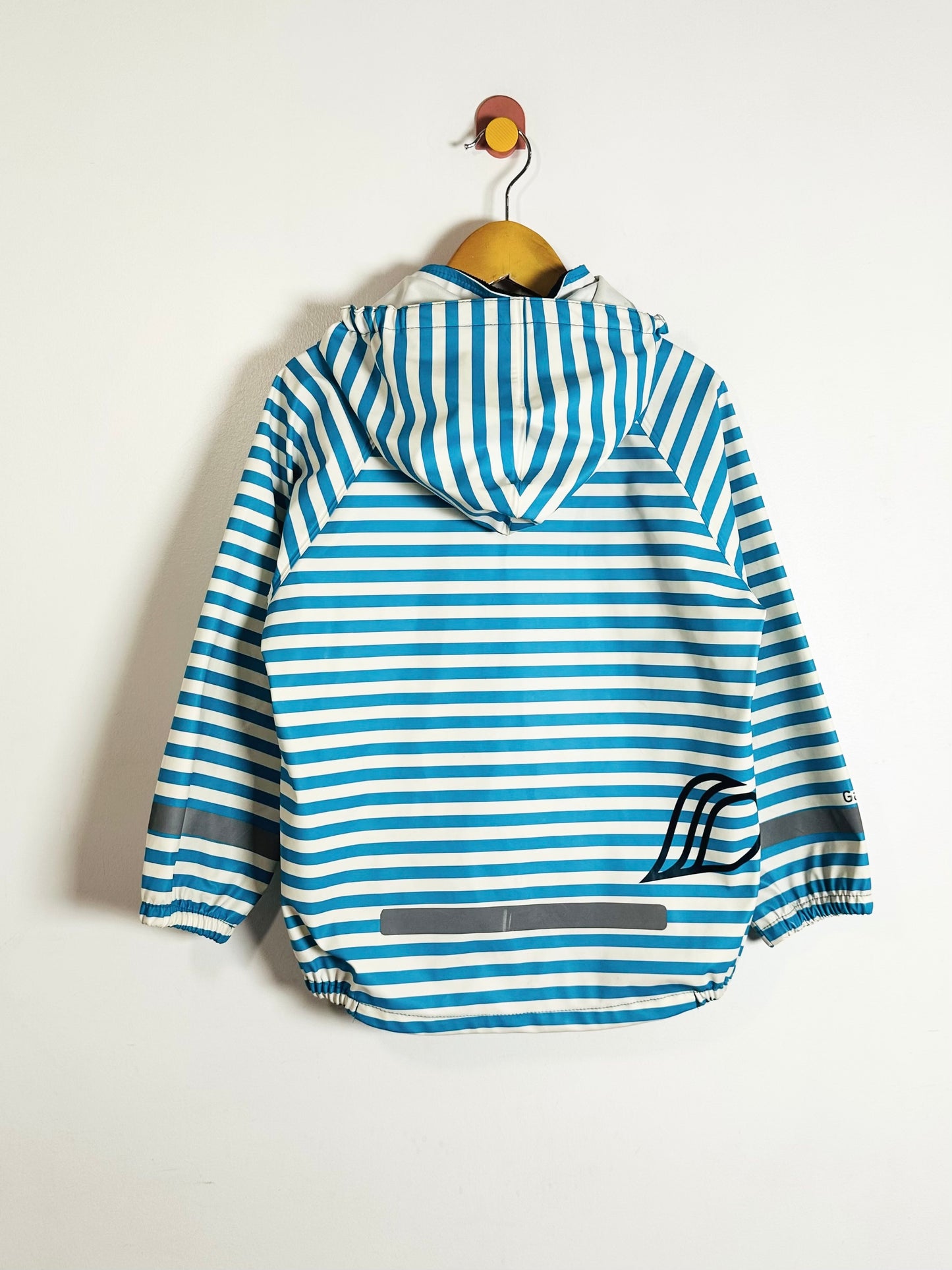 Blue and white striped jacket on a wooden hanger against a light background