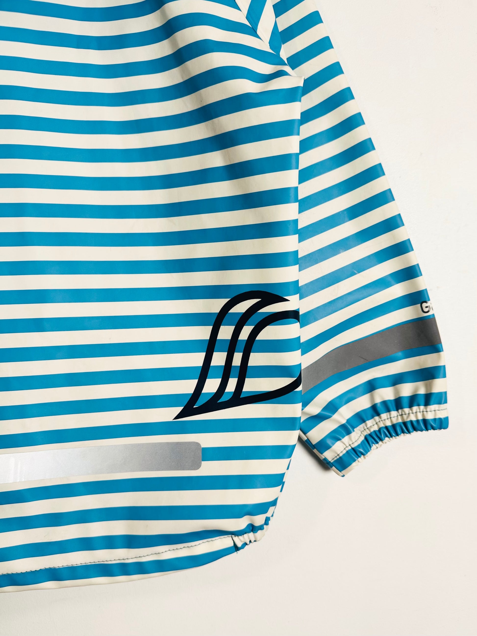 Blue and white striped shirt with a logo on a light gray background