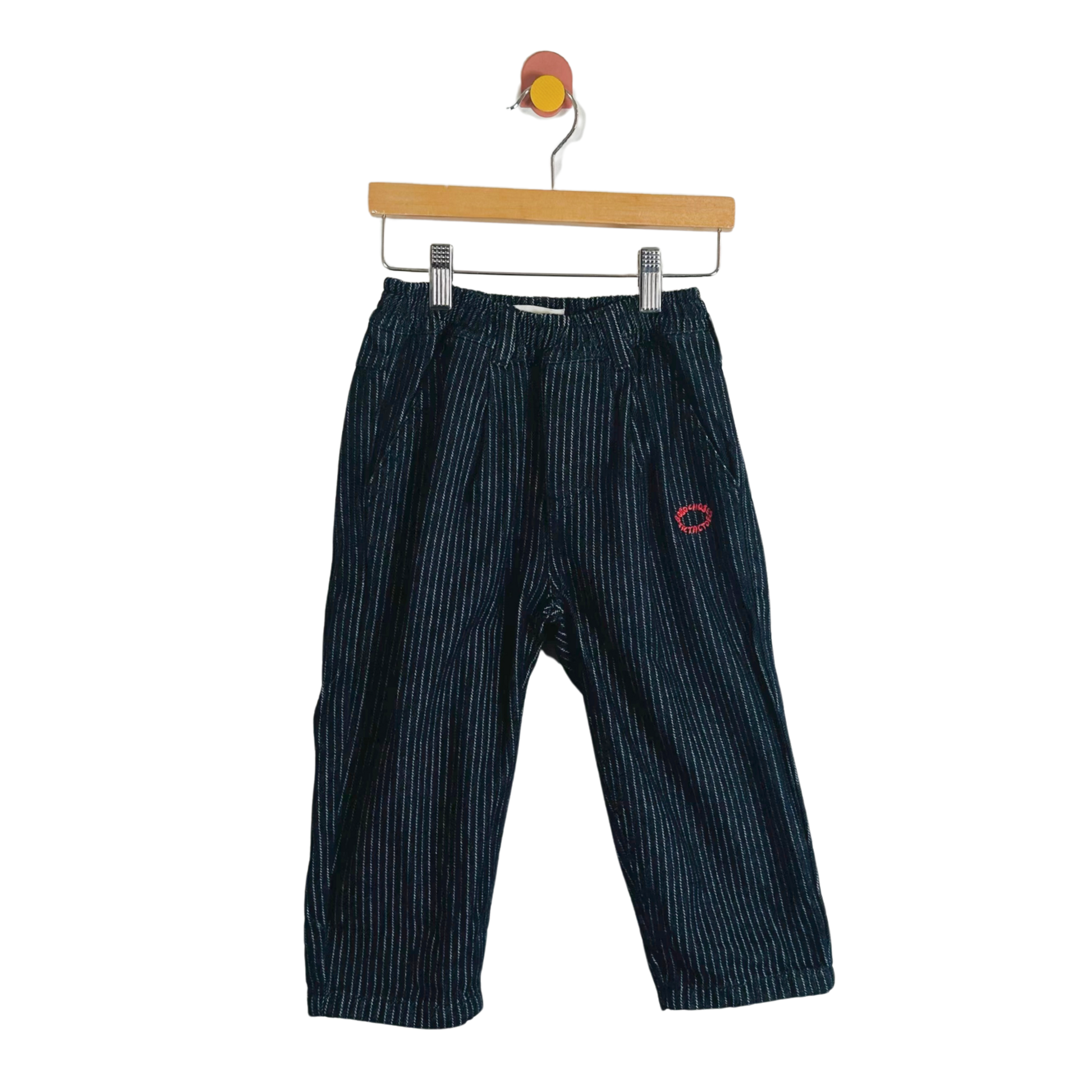 Blue striped pants on a hanger against a white background