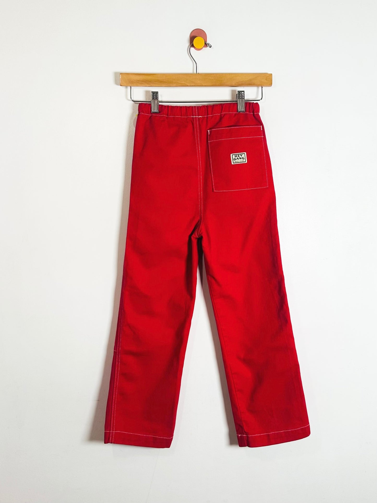 Red pants on a hanger against a white background