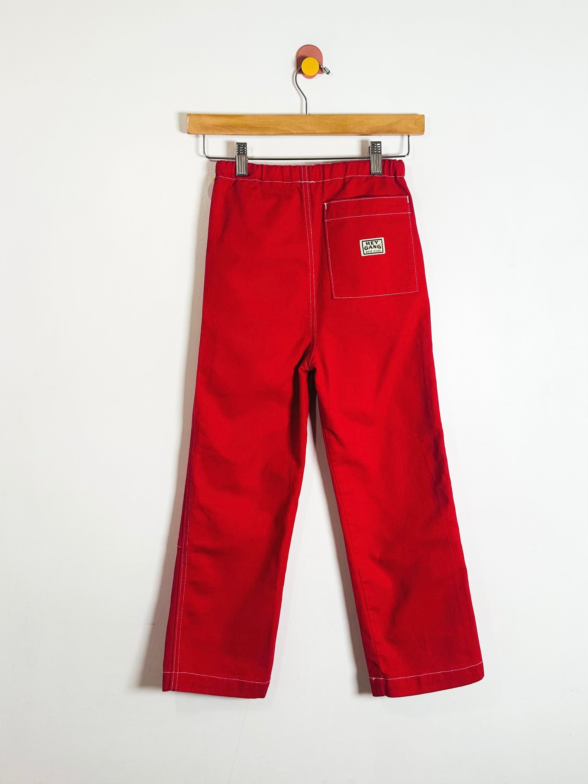 Red pants on a hanger against a white background