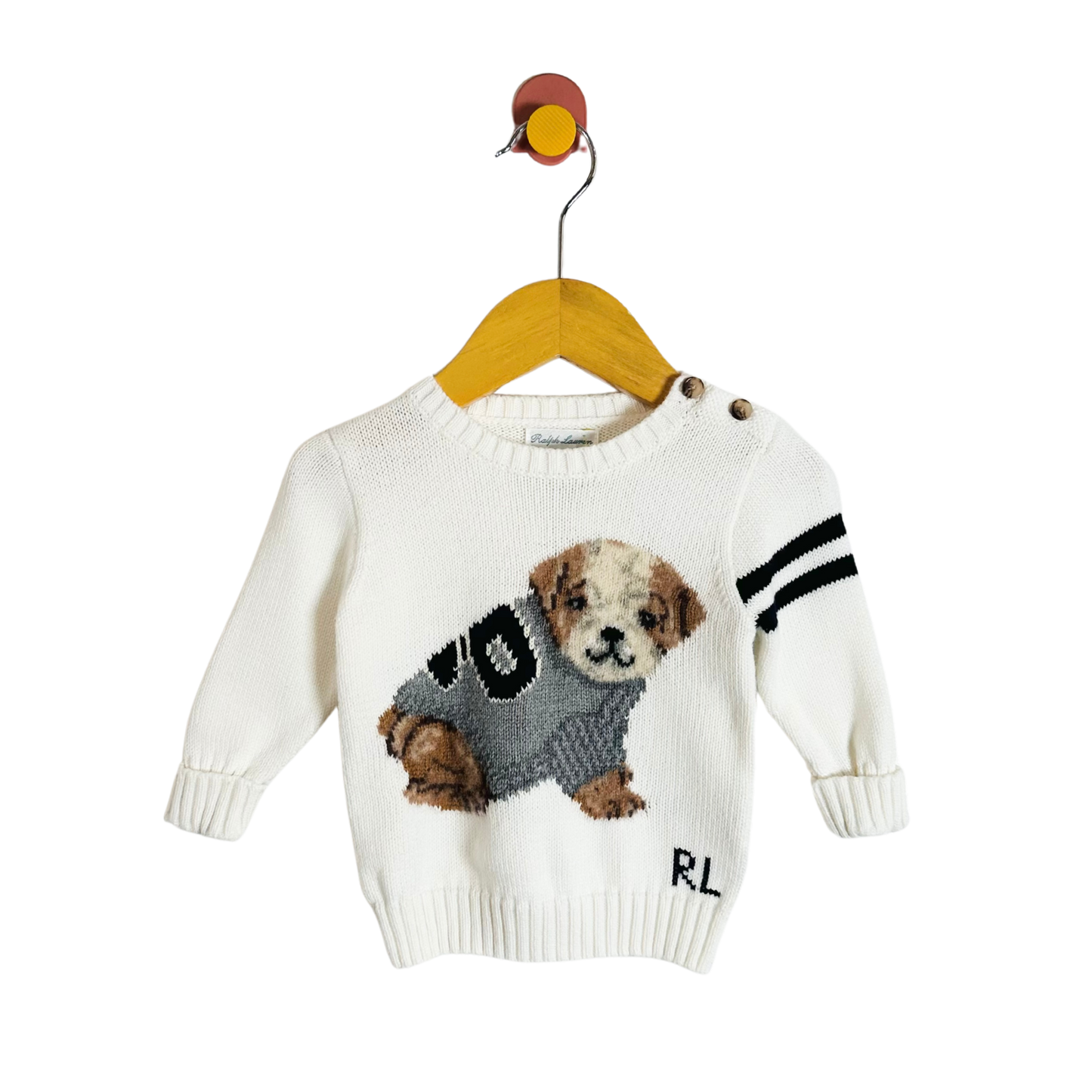 White sweater with dog design on a hanger against a white background